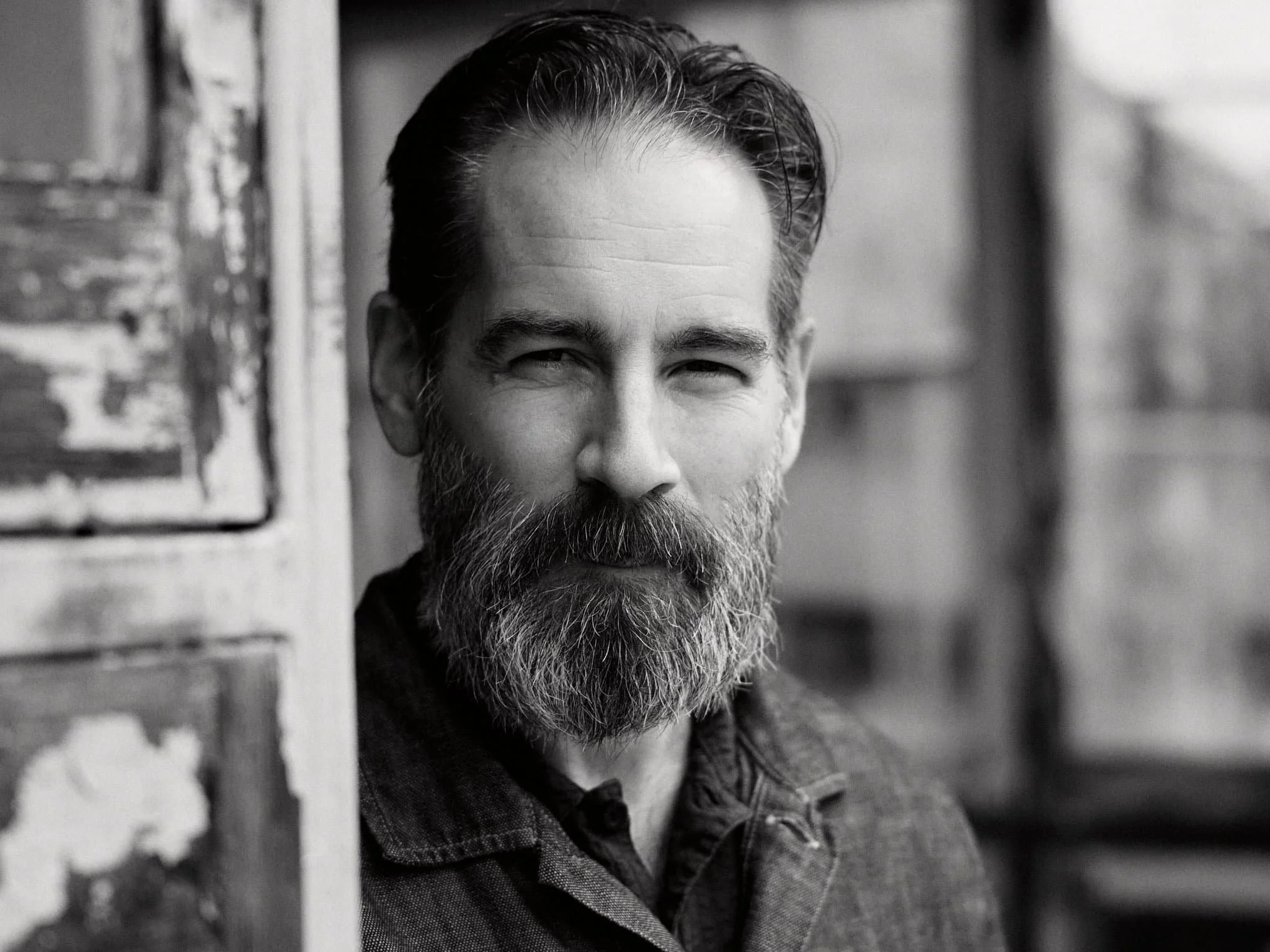 Mann mit Vollbart in alter Scheune s/w