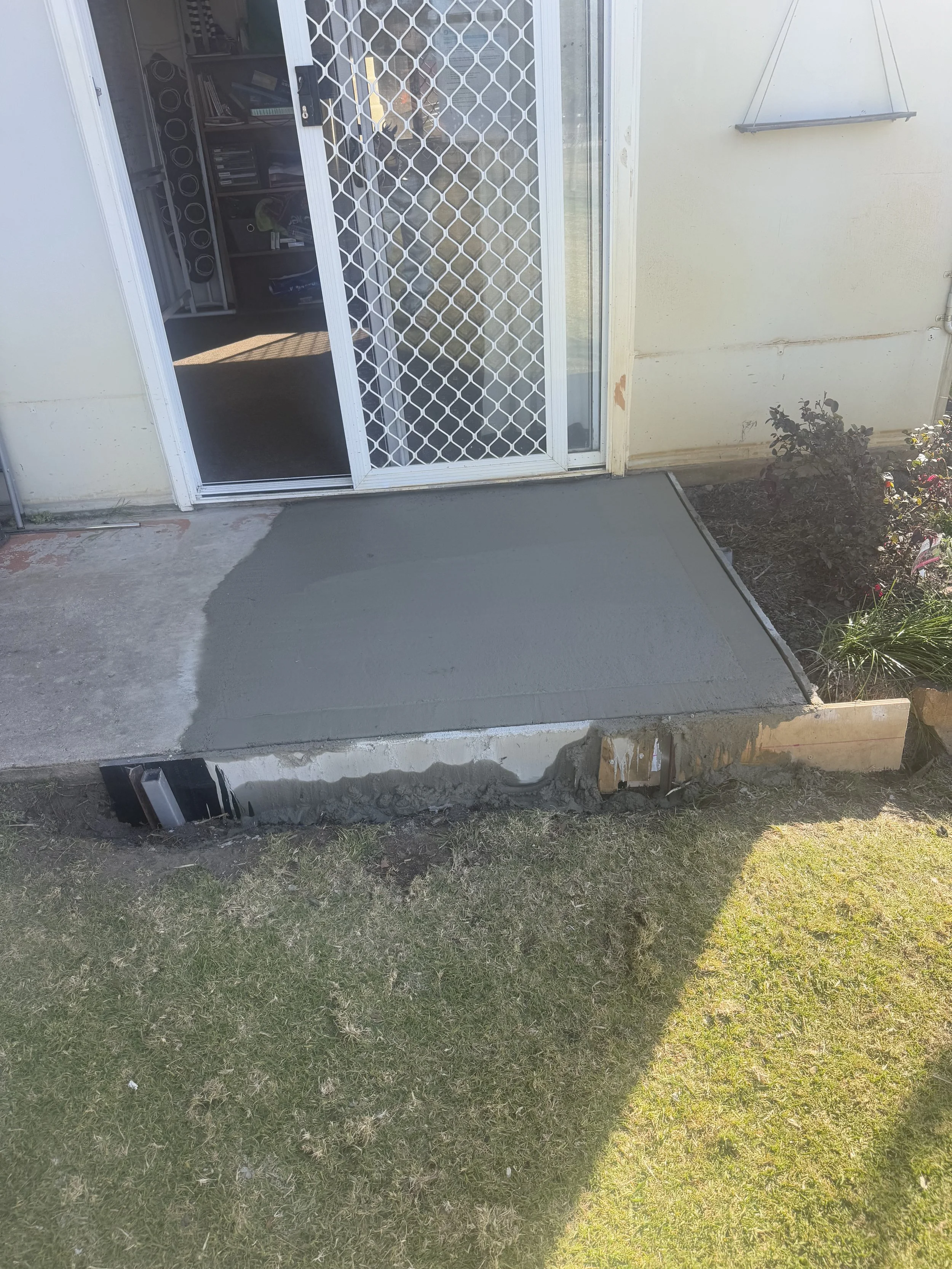 Concrete path extension and entry repair to improve safe access to the doorway.