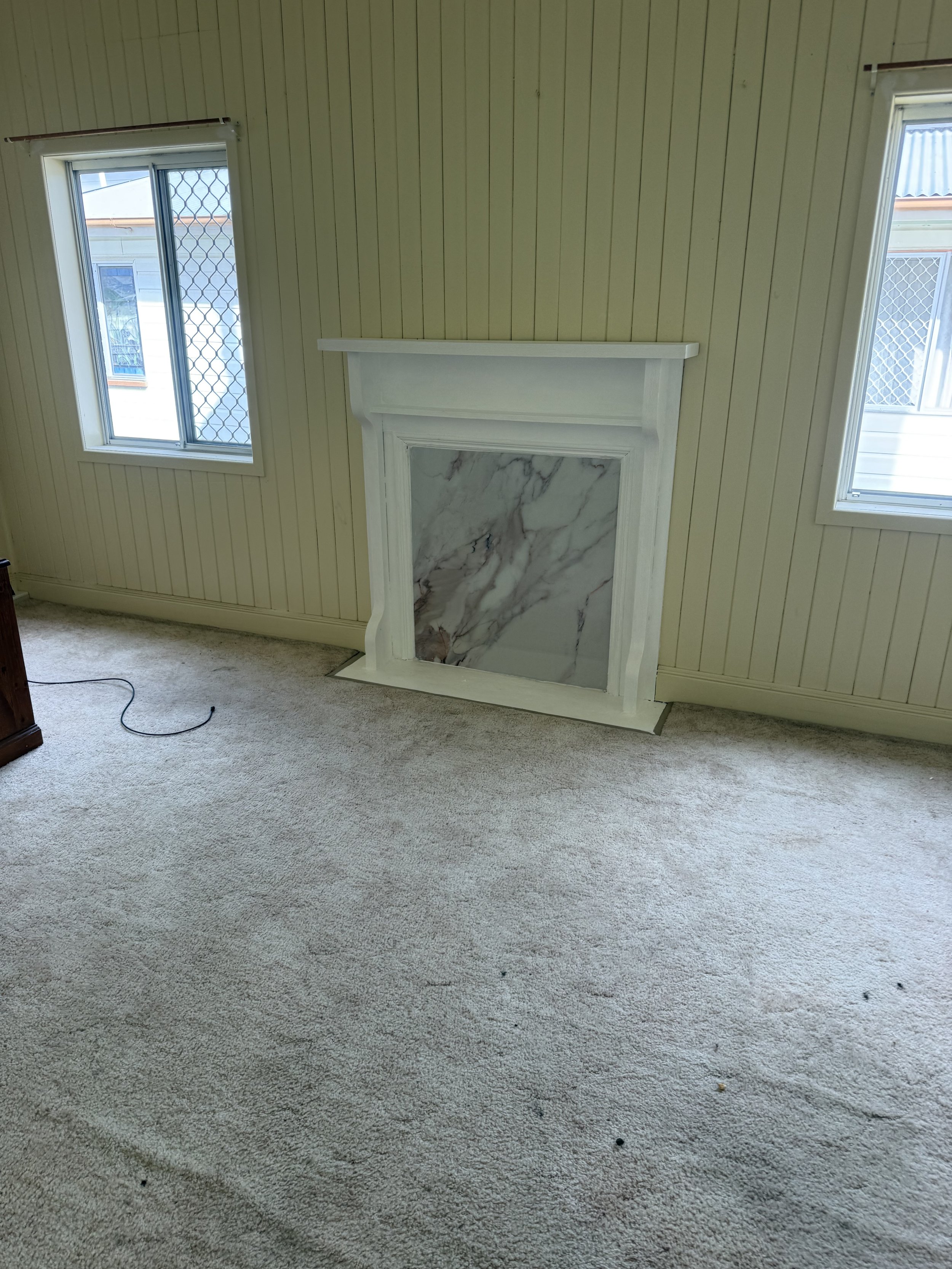 Fireplace surround alteration and wall finishing to close off former fireplace opening.