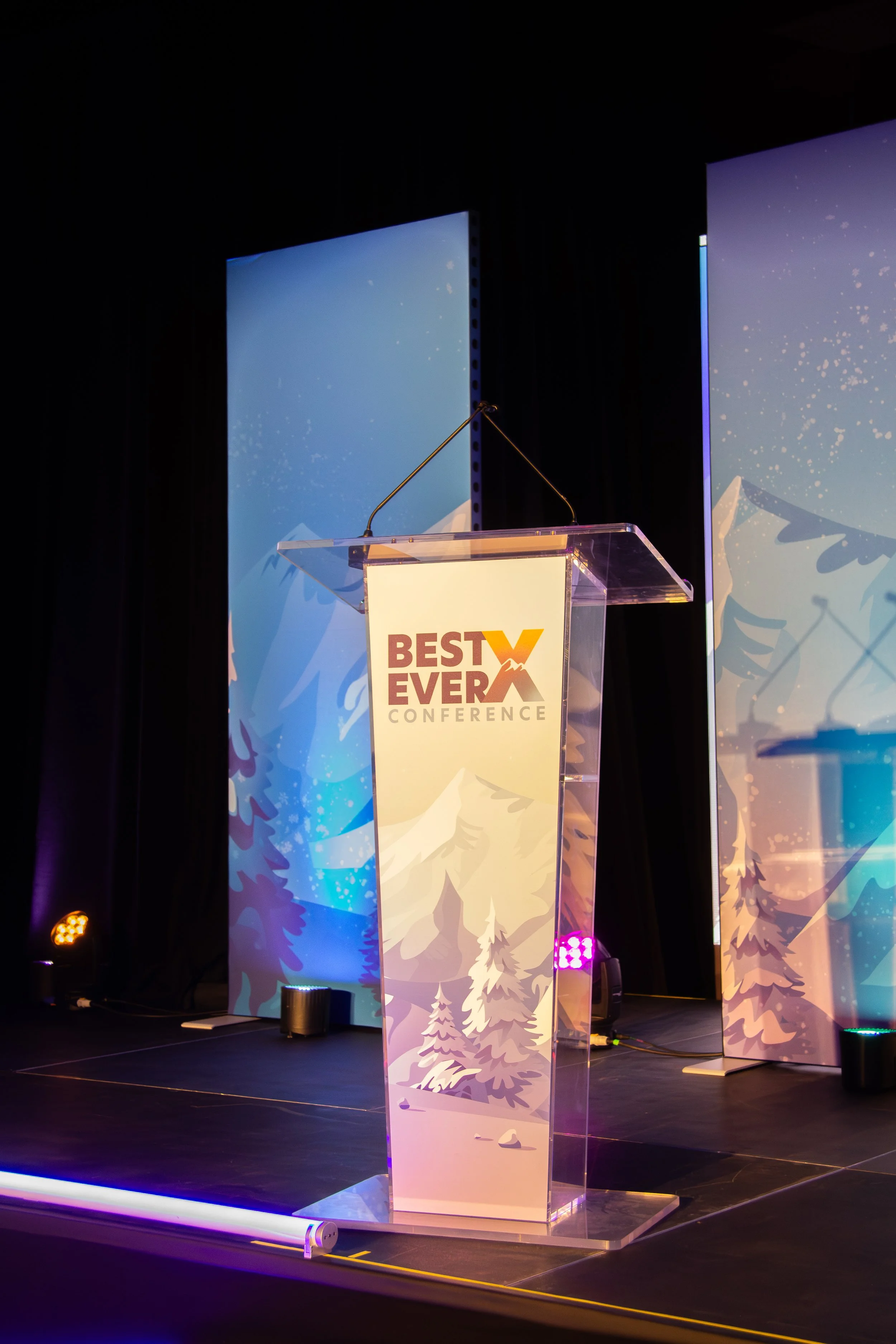 Podium graphic, also mine. Small footprint, high visibility — every speaker stands here, so it needed to be confident without being loud.