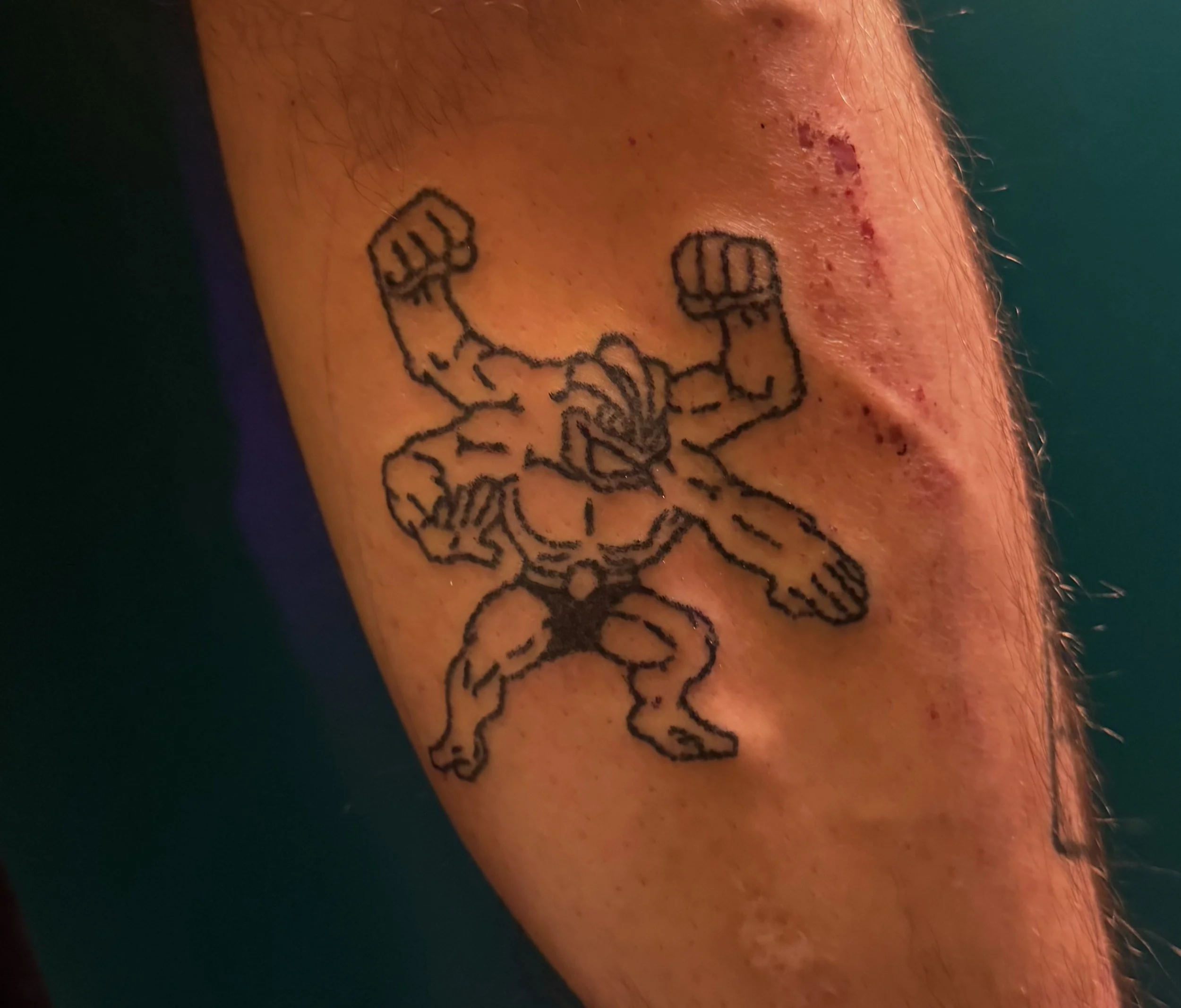 A tattoo of a muscular cartoon-style character wielding two large swords on a person's arm.