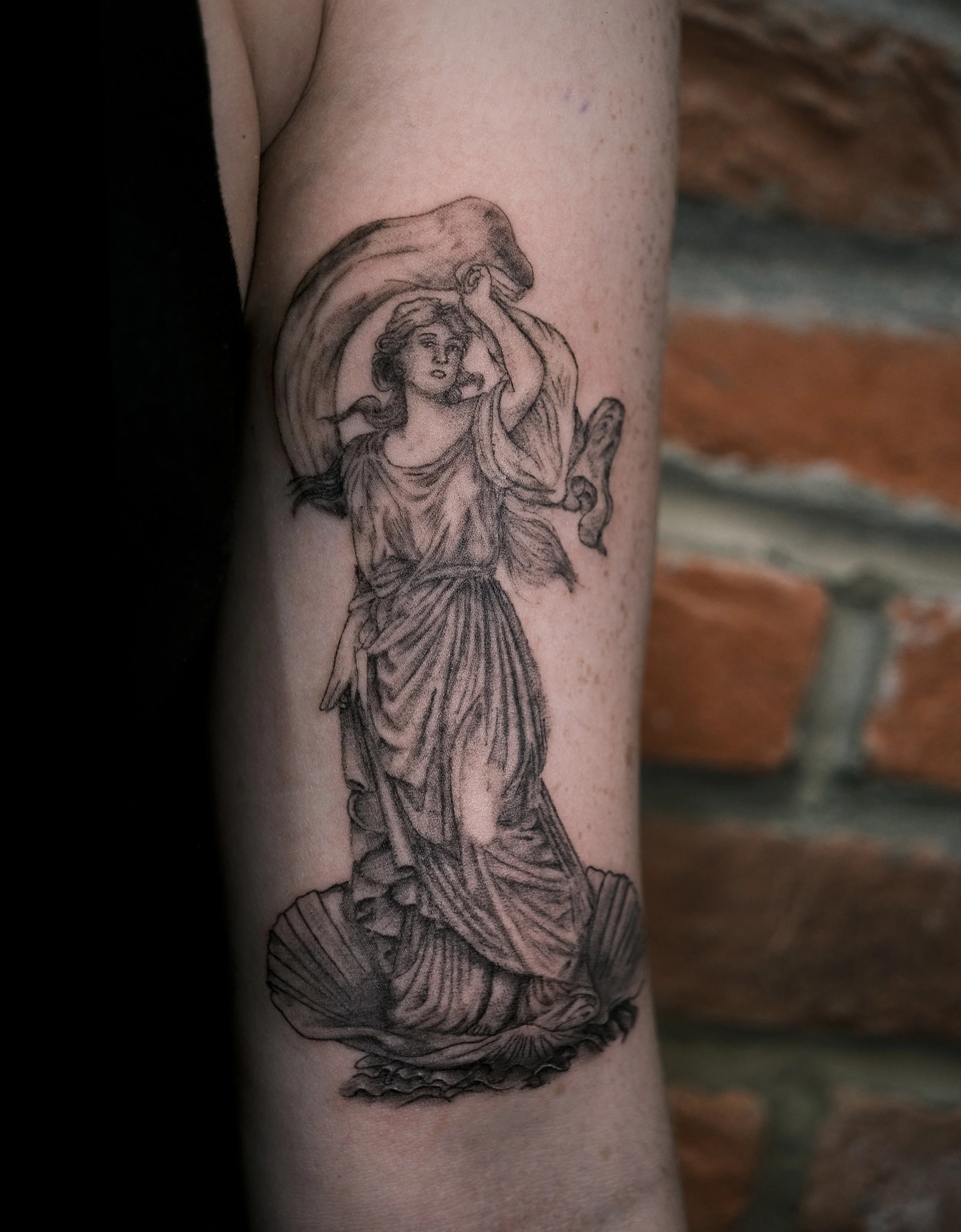 Tattoo of a Daruma doll with one eye filled in, surrounded by flames and Japanese characters.