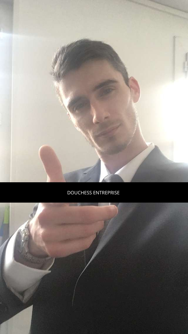 Jeune homme en costume fait un geste de la main, fond lumineux, texte "DOUCHE ASS ENTREPRISE"