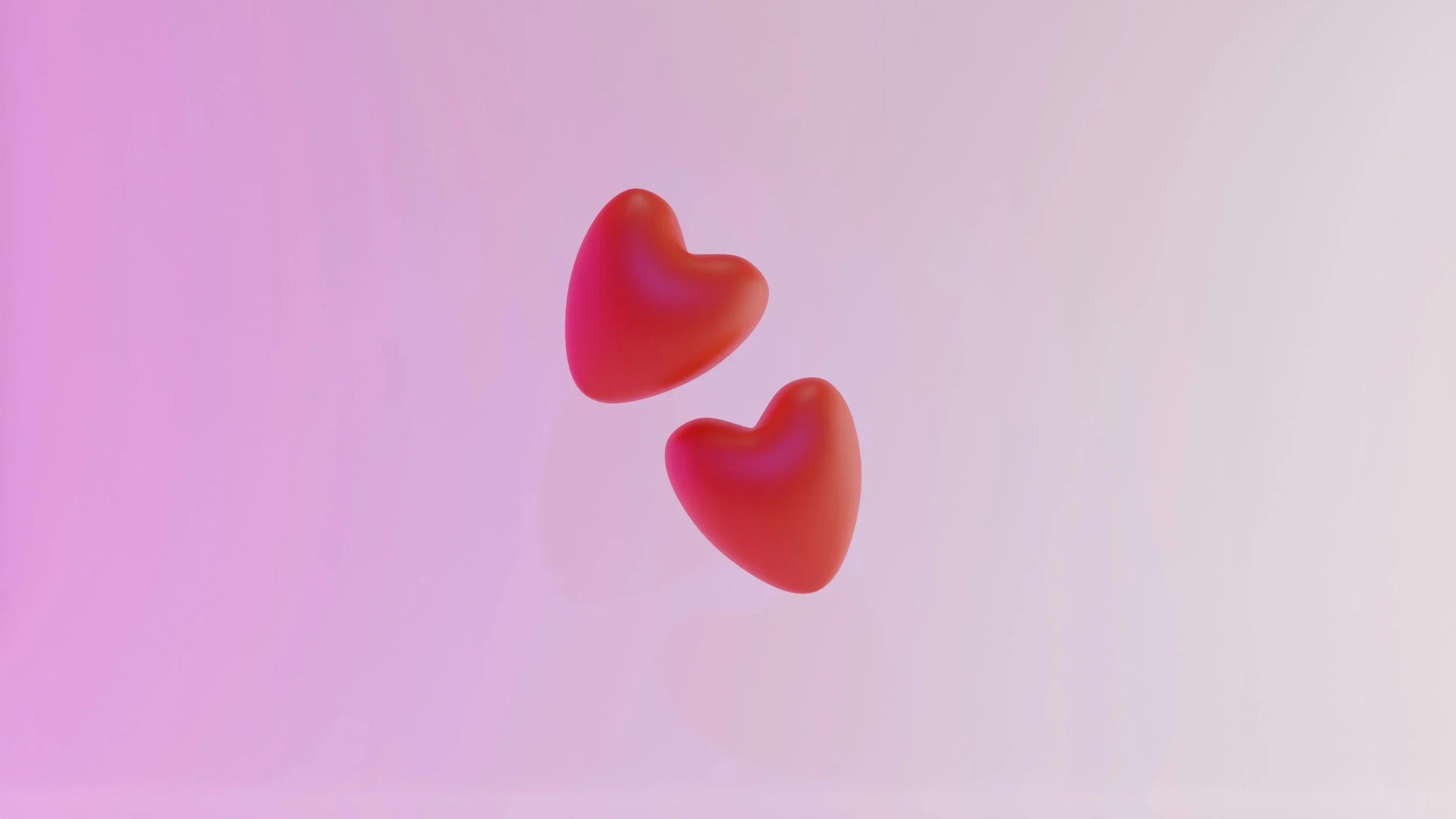 Deux cœurs rouges flottants dans un fond dégradé rose et violet.
