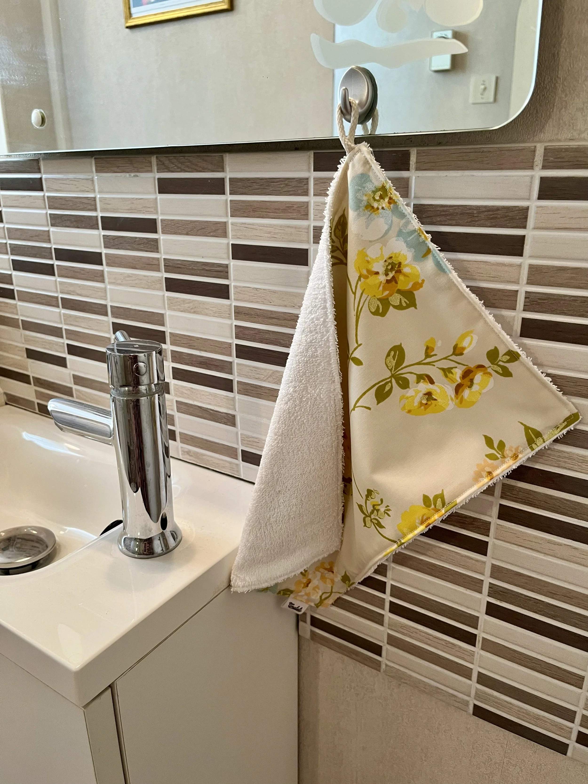 Une serviette douce et responsable pour prendre soin de toi ! Confectionnée à partir de textiles revalorisés (tissu et serviette), elle allie confort et engagement.  Chaque modèle est unique et pensé pour un usage quotidien.  