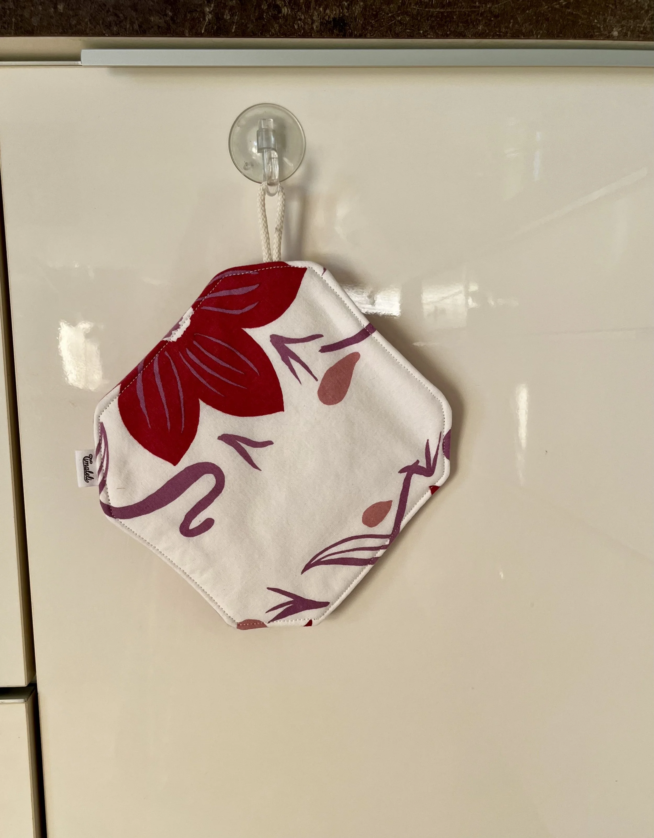 Cuisiner avec un accessoire qui a une histoire !  Cette manique Timaleli est confectionnée à partir de textiles revalorisés (tissu et serviette) pour accompagner les petits gestes du quotidien en cuisine.  Pratique et fabriquée à la main.