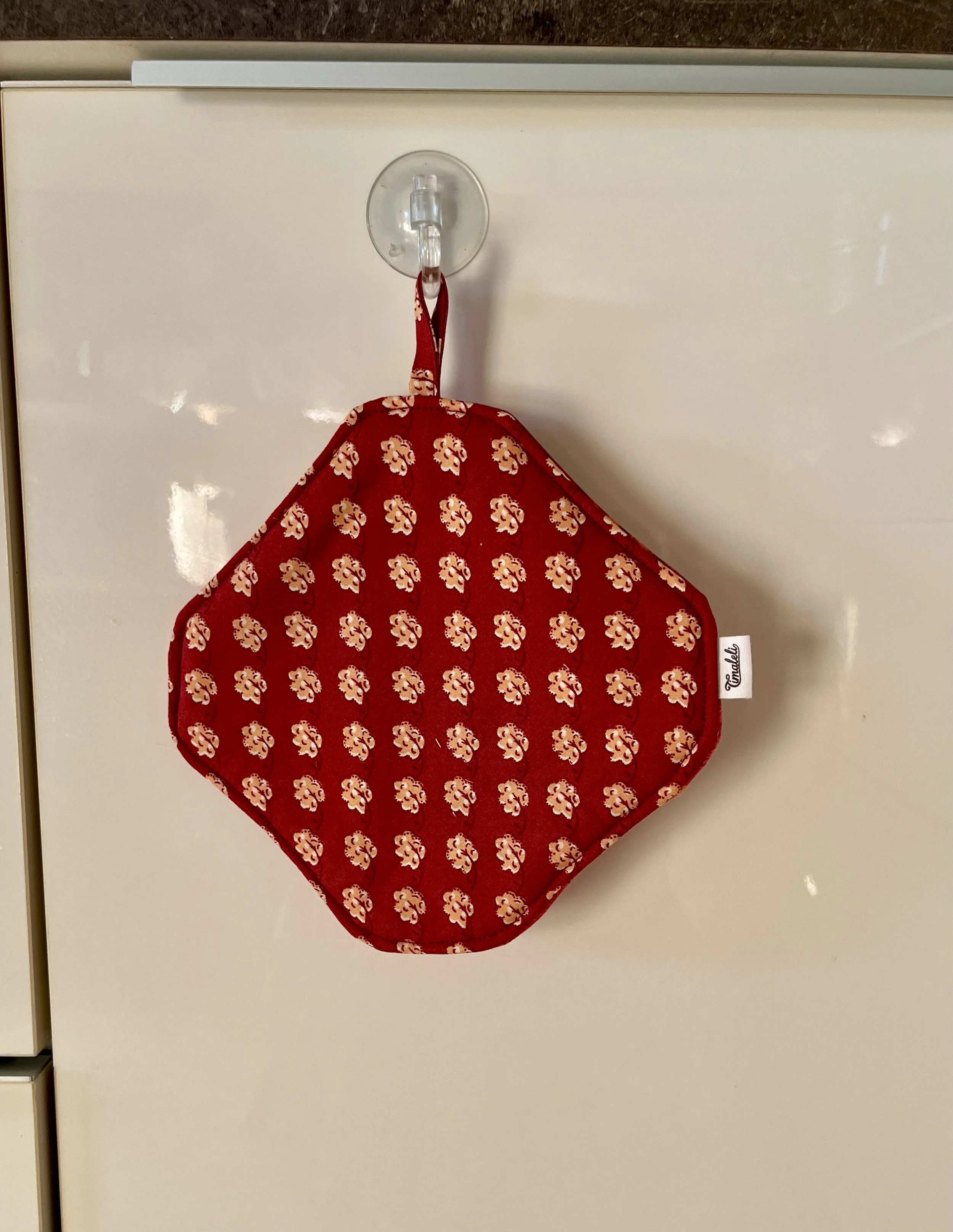 Cuisiner avec un accessoire qui a une histoire !  Cette manique Timaleli est confectionnée à partir de textiles revalorisés (tissu et serviette) pour accompagner les petits gestes du quotidien en cuisine.  Pratique et fabriquée à la main.