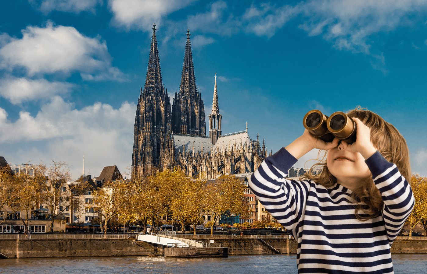 Kind schaut mit Fernglas auf den Kölner Dom und entdeckt die Stadt bei einer selbstgeführten Kinder Stadterkundung in Köln
