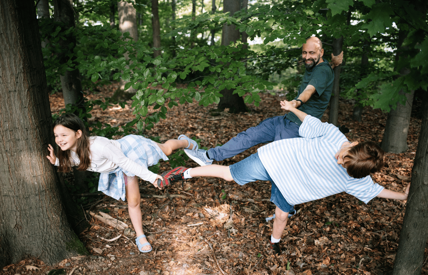 Familie und Kinder spielen im Wald bei einer Outdoor Schnitzeljagd Kinder und erleben ein gemeinsames Natur Abenteuer