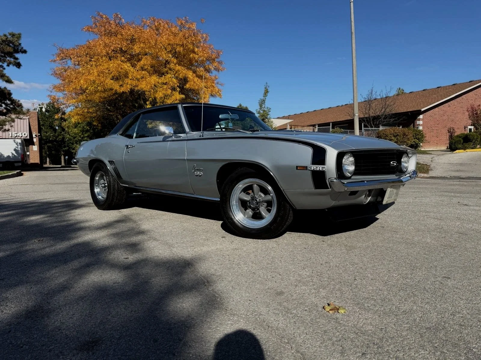 Inside view of a modern car's dashboard and center console, showing a gear shift, control knobs, and a large display screen reading 'Good afternoon'