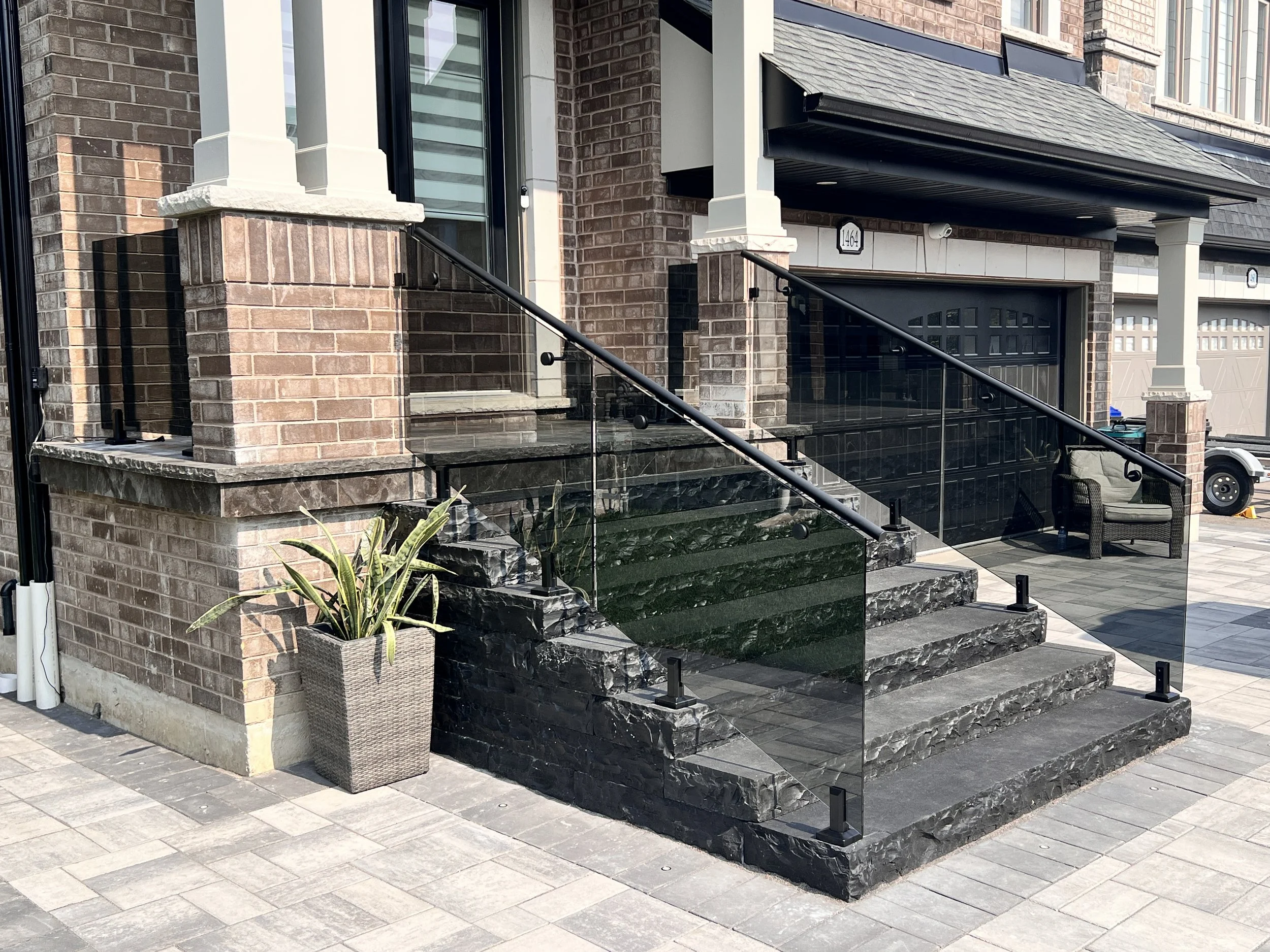 Exterior tinted glass railing on stone steps located in Innisfil