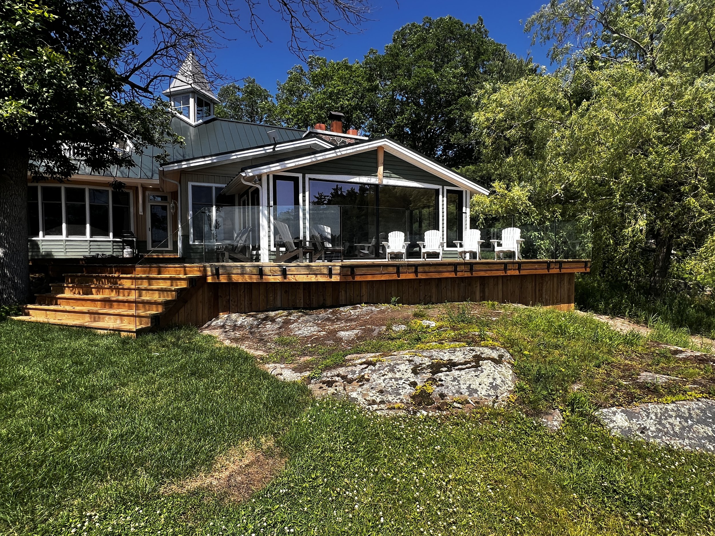 Custom glass railing in Muskoka on a deck overlooking the lake.