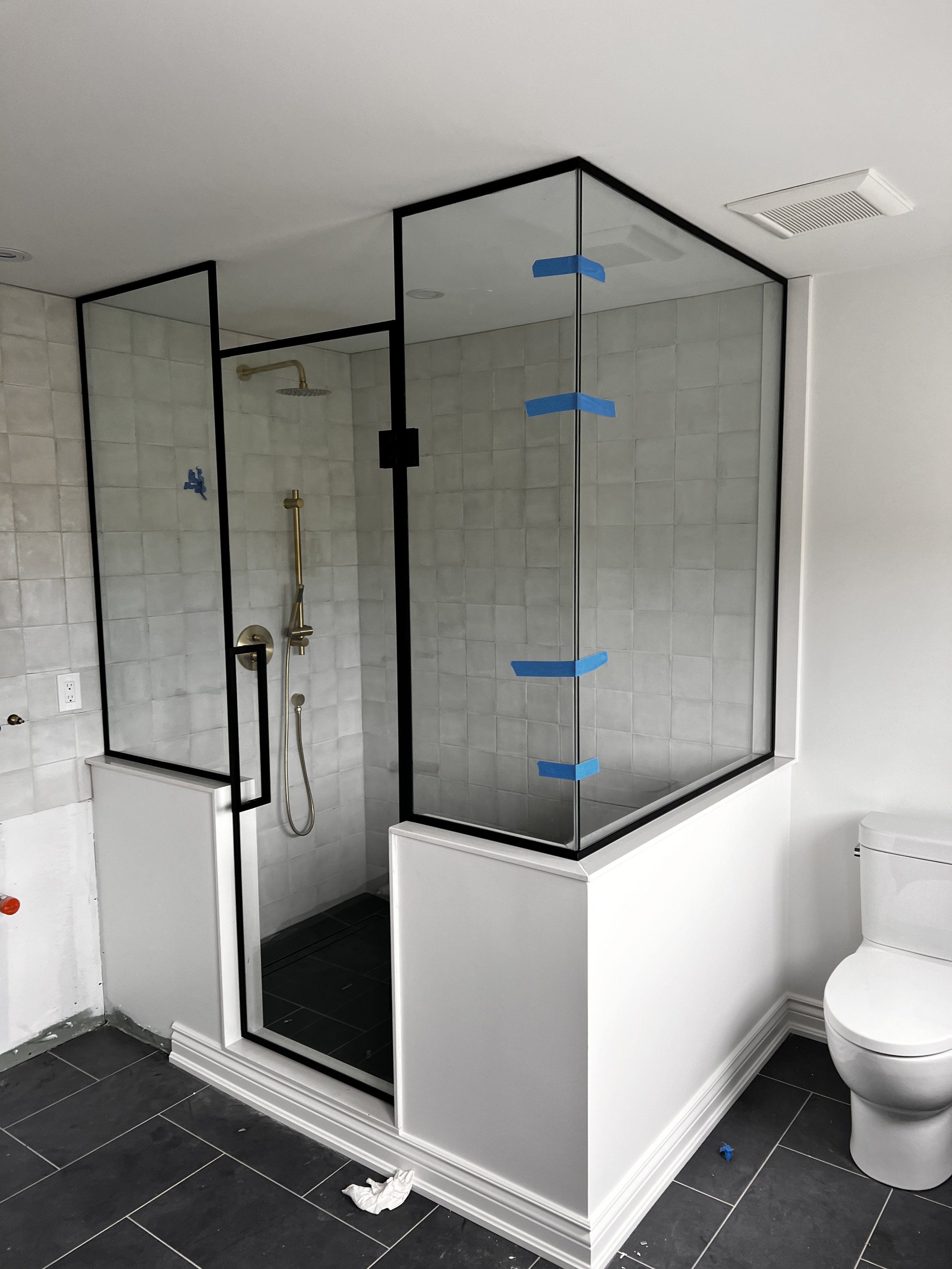 Custom Oversize Glass Shower with Black Frame in Collingwood, Ontario – This stunning oversized glass shower features a sleek black frame border, adding a bold, modern look to the spacious bathroom. The combination of frameless glass panels and minim