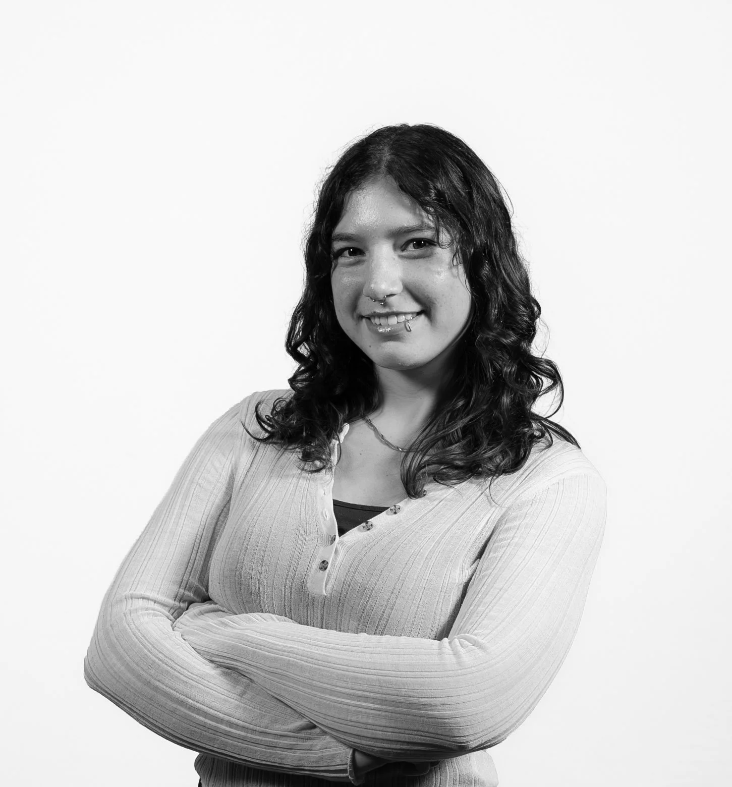 Headshot of Sirena Alvarez with arms crossed and smiling