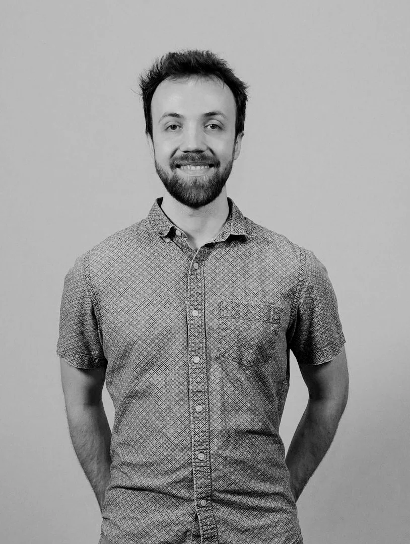 Headshot of Rob Lista with arms behind his back while looking at the camera.