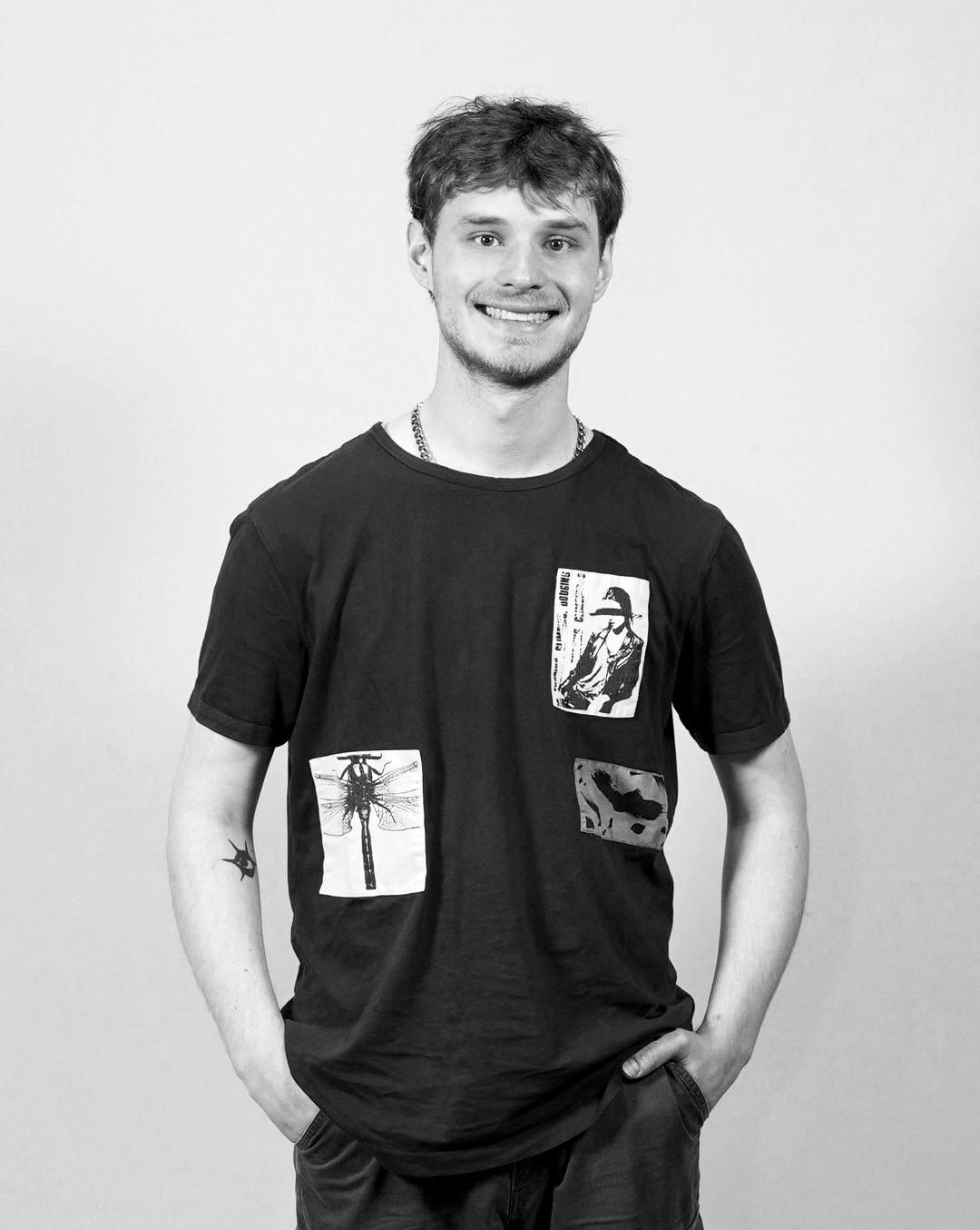 Headshot of Bryson Christopher smiling and standing with hands in pocket