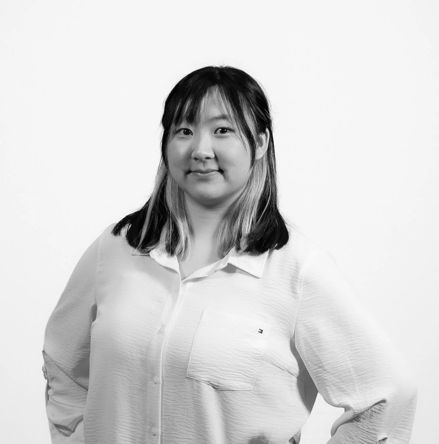 Headshot of Elisa Lee, smiling with hands on hips