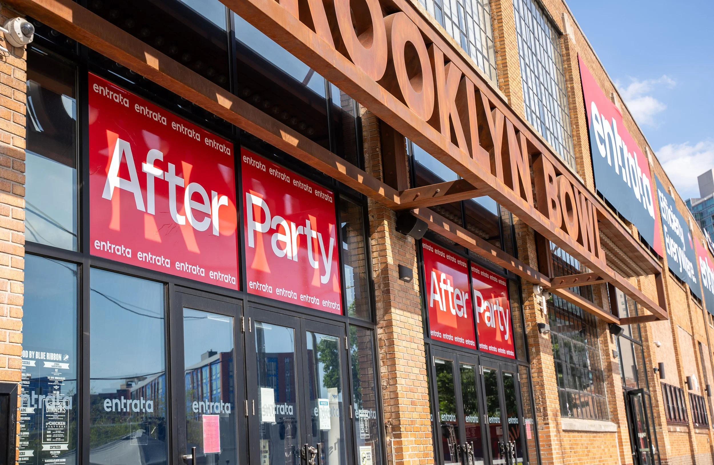 A series of doors and banners hang on the outside of the Brooklyn Bowl venue in Philadelphia with text that reads: Entrata After Party.