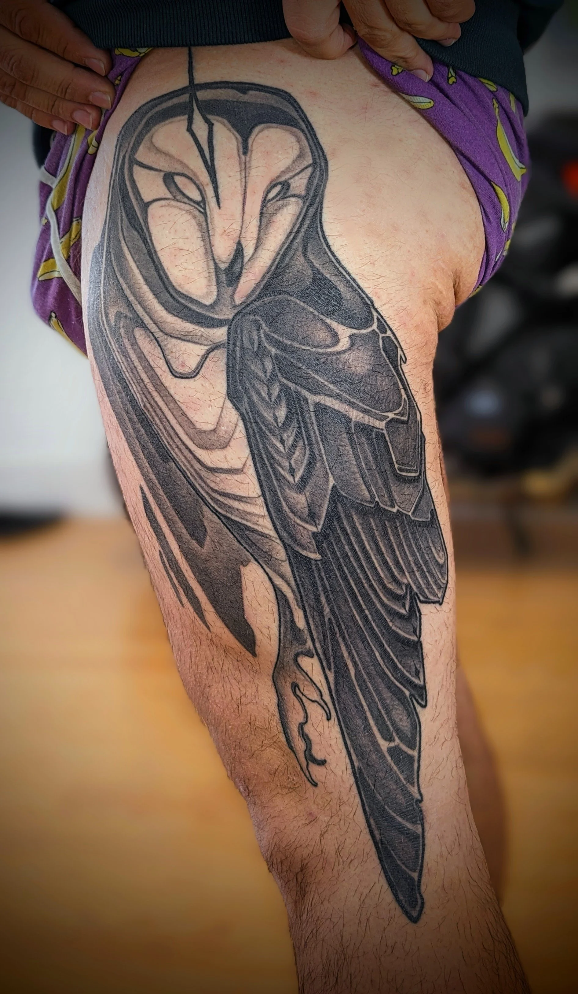 A large, detailed black and gray tattoo of a wasp on a person's thigh.