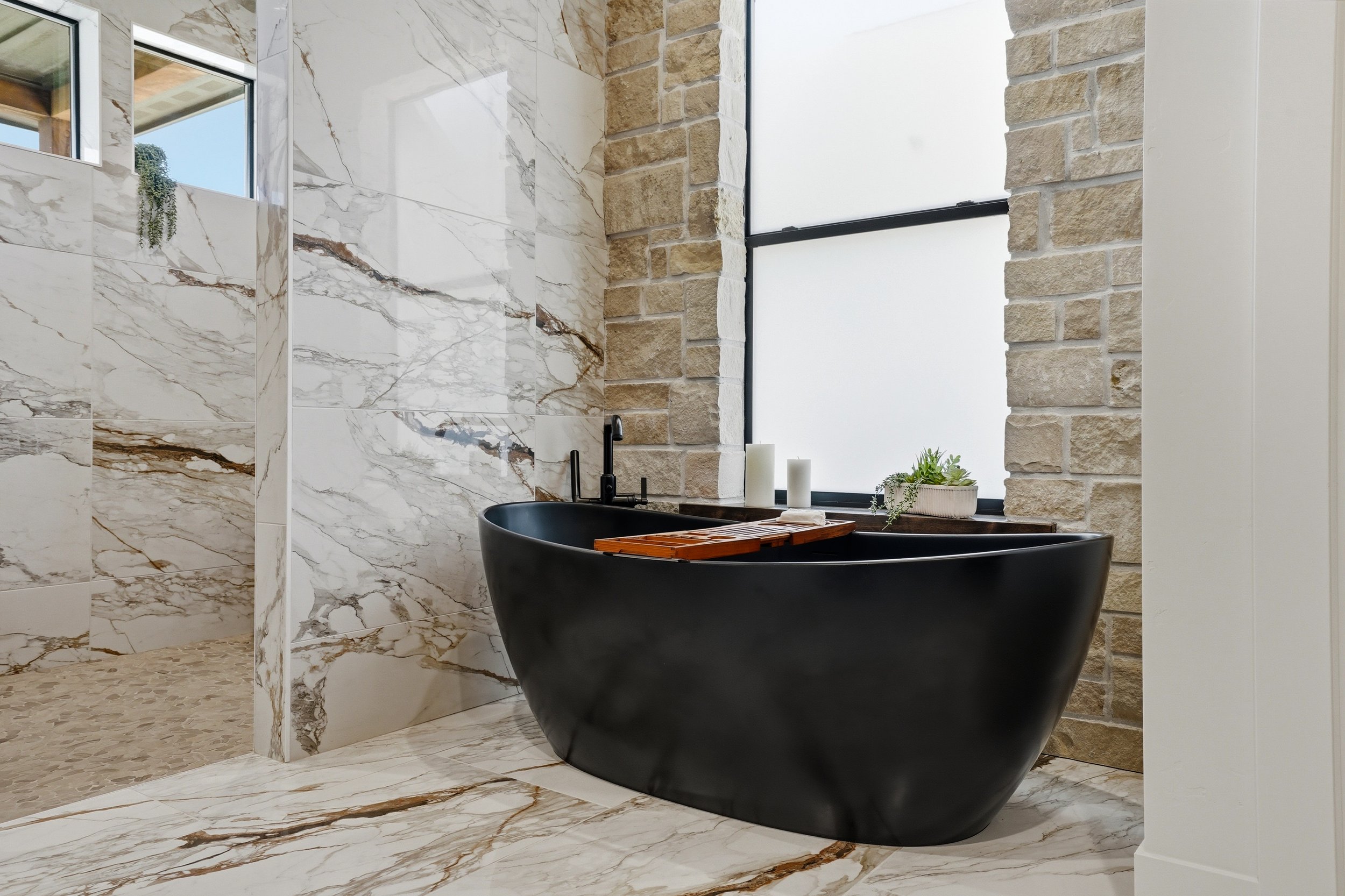 Black soaking tub and marble primary bathroom in The Cody, 2026 Parade of Homes Primary Suite winner