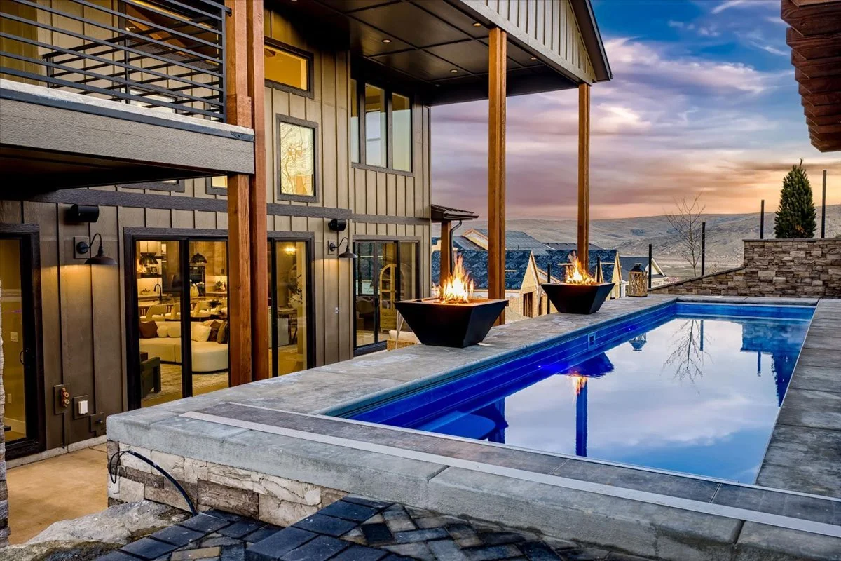 Modern custom home exterior with rooftop pool deck and twin fire bowls overlooking the Eagle foothills at sunset, Valnova, Idaho
