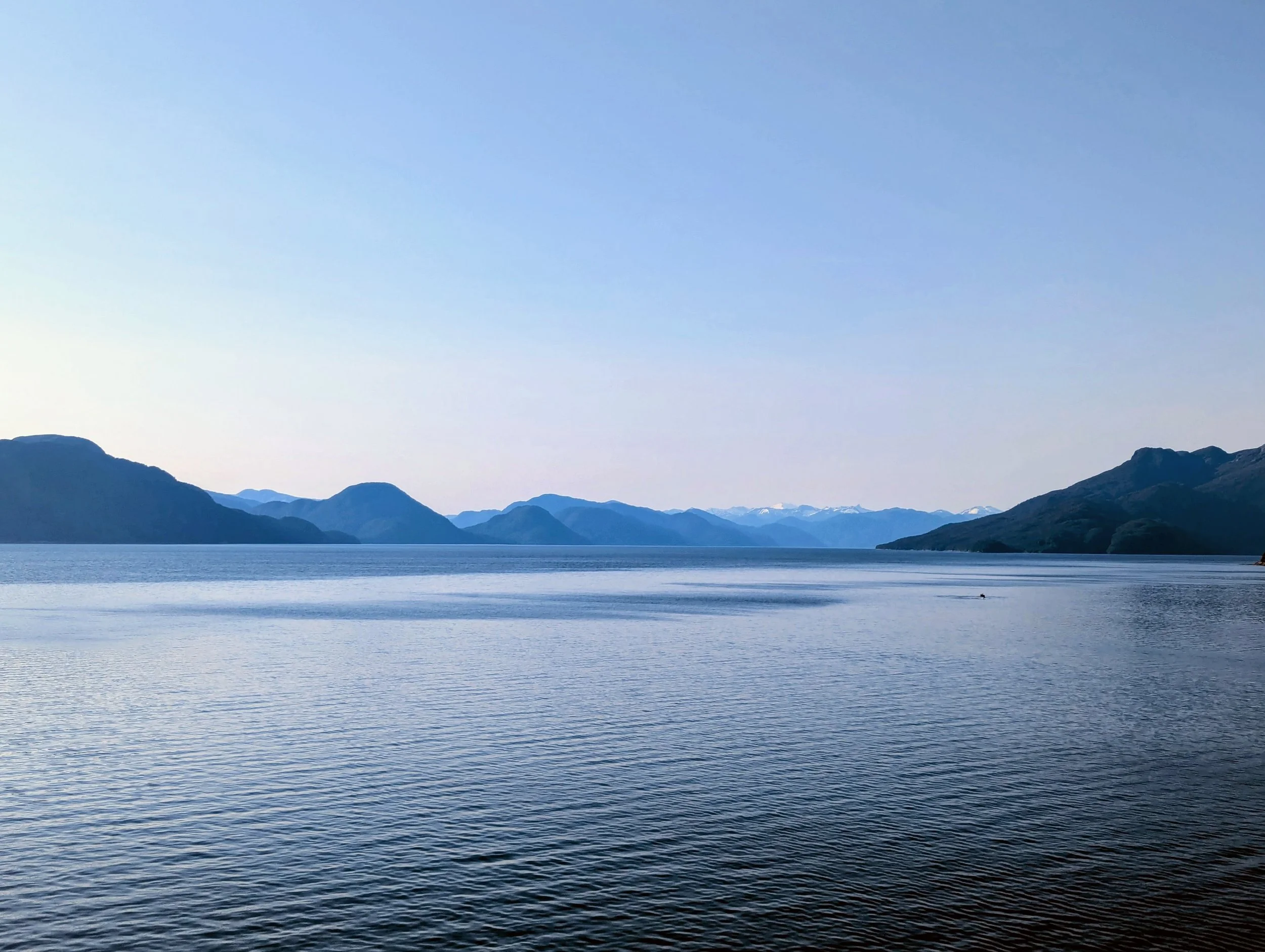 View from cruise ship balcony looking out at dramatic Alaska Inside Passage fjord scenery