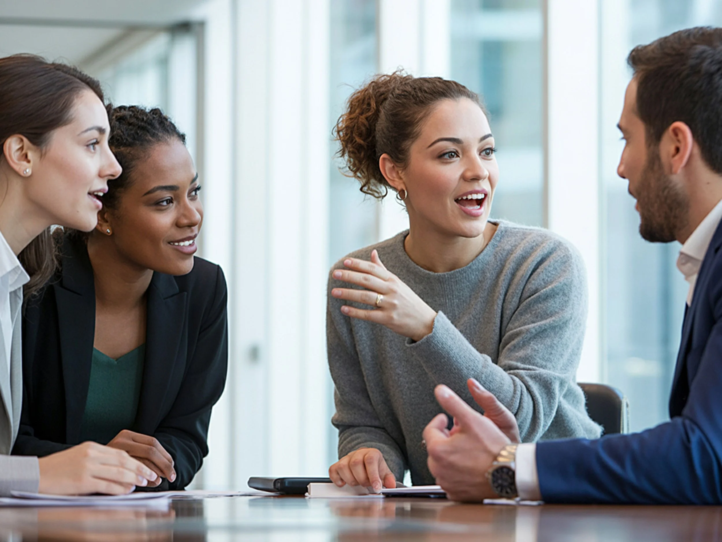 Small professional team collaborating confidently in modern bright office space