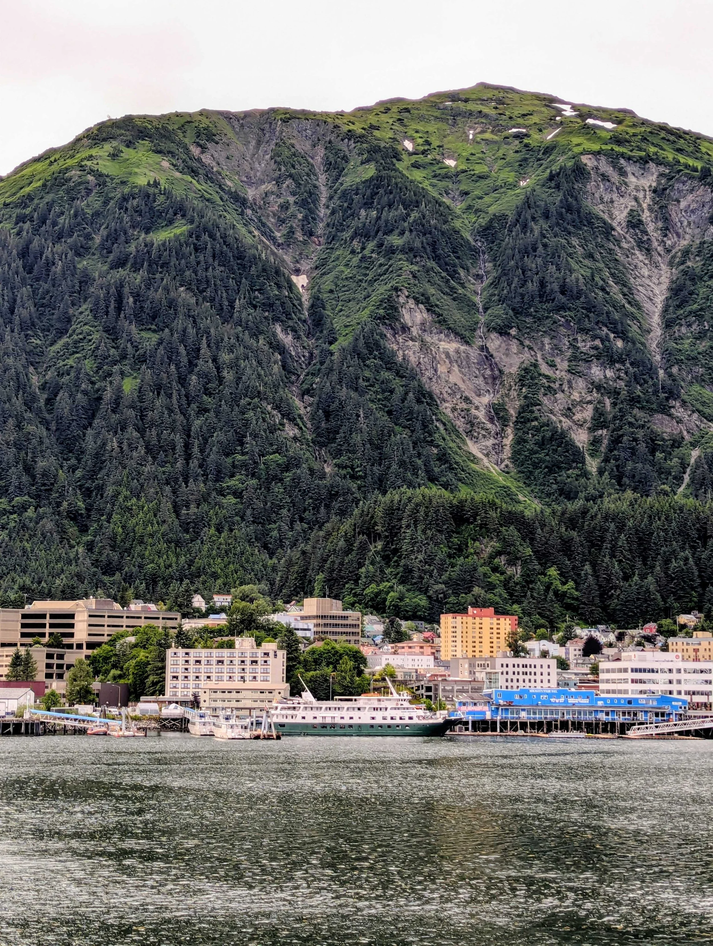 Docked in Juneau, Alaska with a view of buildings under a towering green mountain