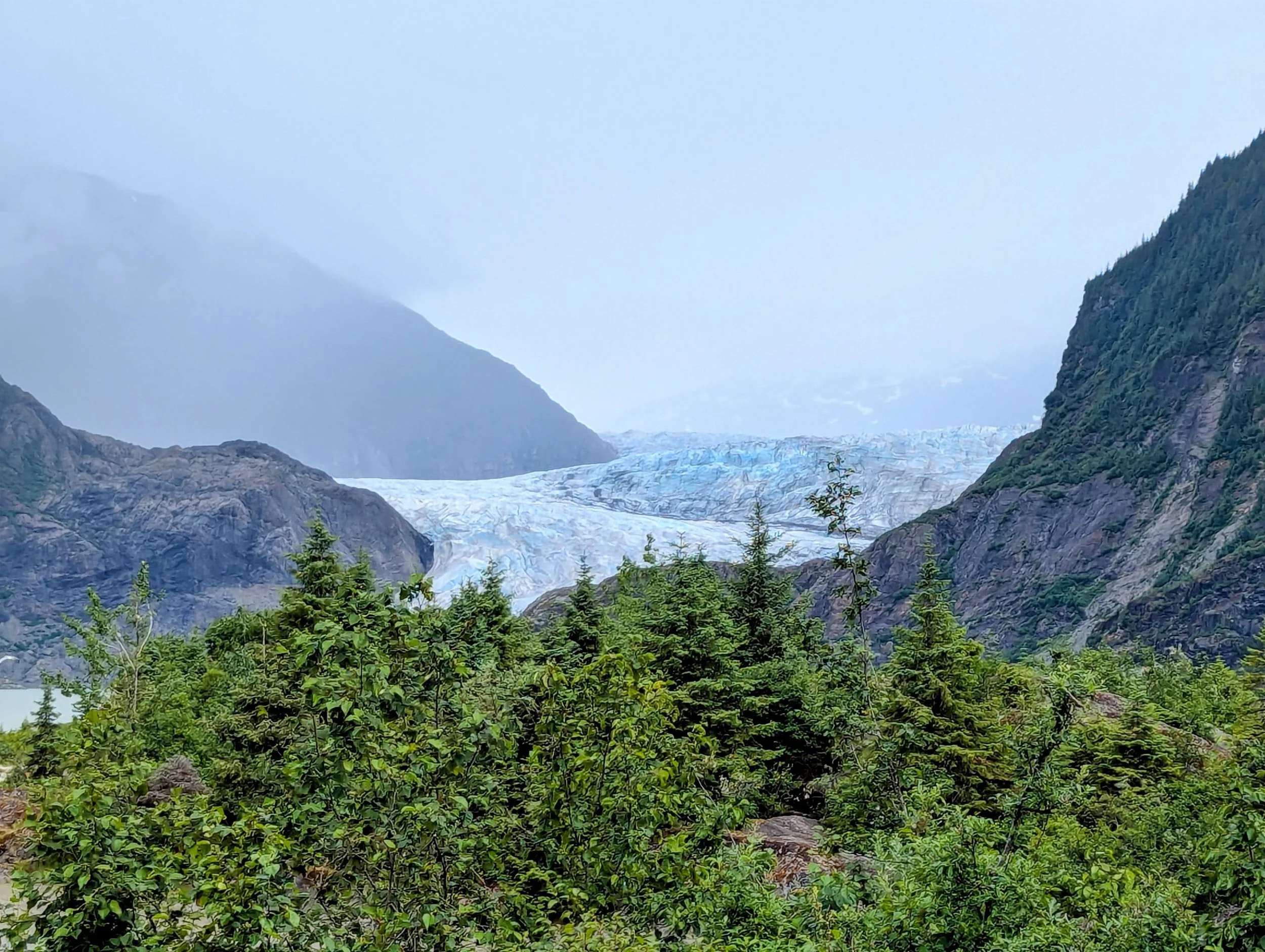 View of Mendenhall Glacier and a lake from the top of a hill