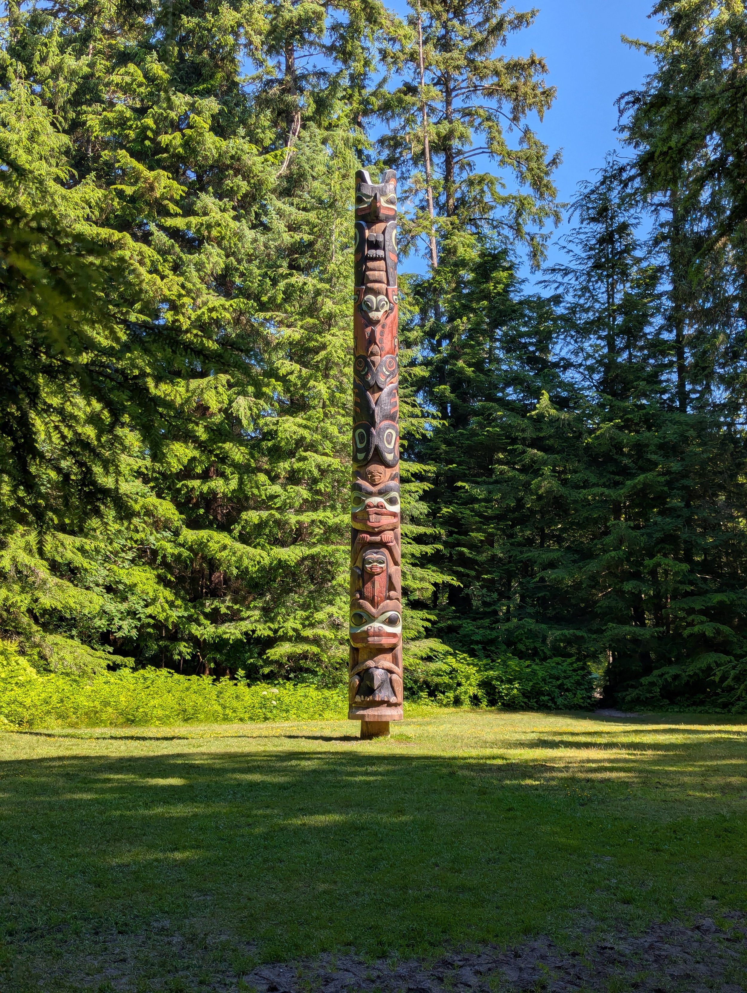 Tlingit totem poles standing among trees in Sitka National Historical Park Alaska
