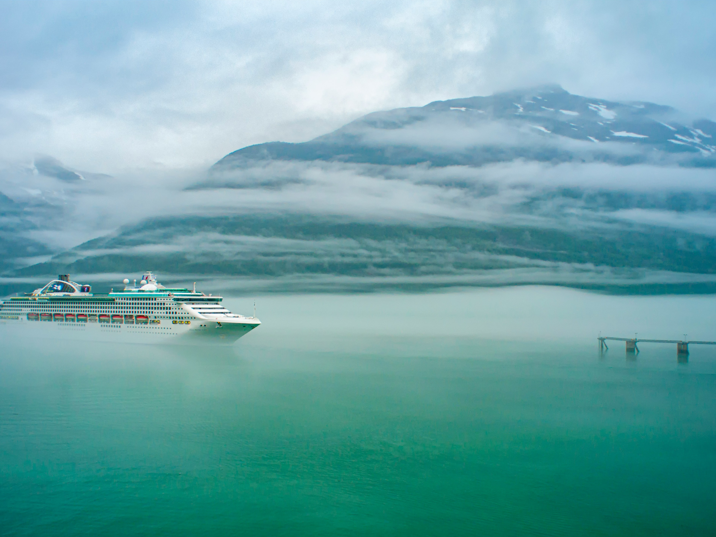 Dramatic Alaska glacier landscape reflecting in calm water on a cruise sailing
