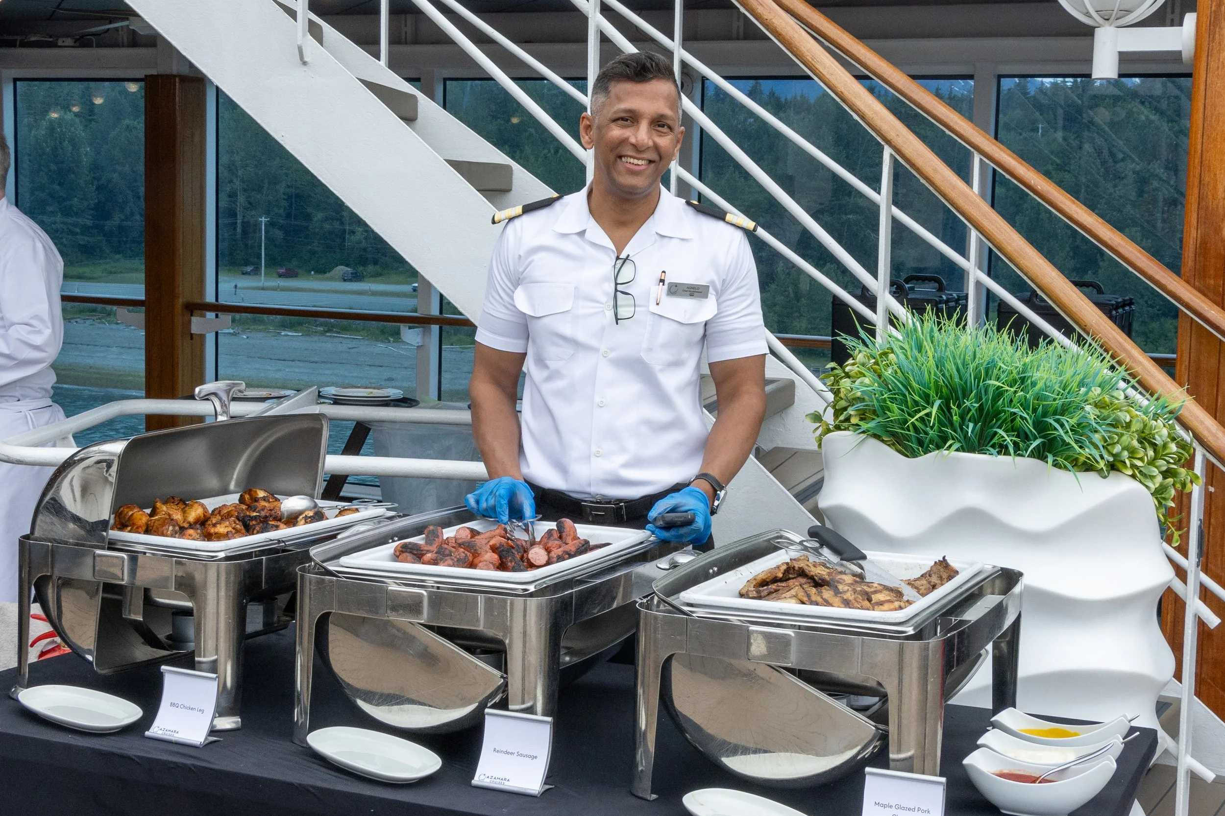 An officer serving dinner at the Officer's BBQ onboard Azamara Pursuit