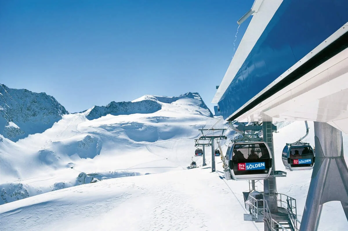 Gondolas of a ski lift in Solden with a clear blue sky in the background.