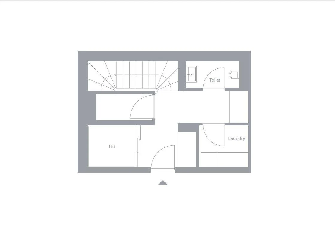 Floor plan of a small building with stairs, lift, toilet, laundry, and entrance.