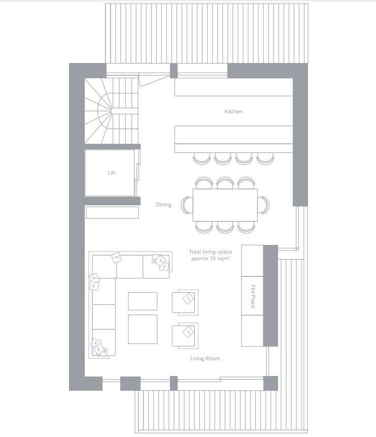 Floor plan of a living space with a living room, a dining area, a kitchen, and a staircase. The living room has a large sectional sofa, coffee tables, and a fireplace. The dining area has a large table with seating for eight. The kitchen is situated behind the dining area with counters and an island. There is a balcony or patio on the right side of the layout.