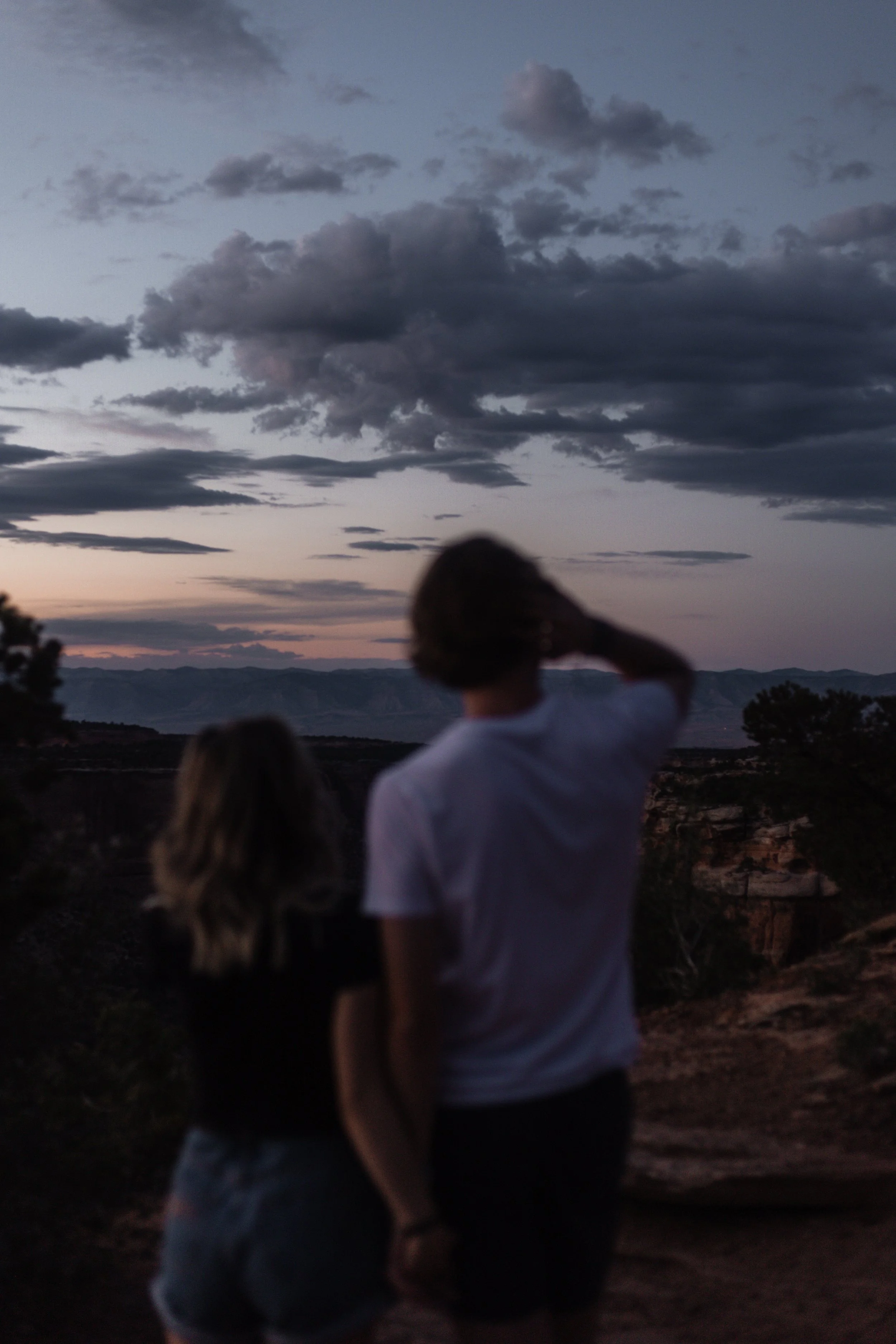 People watching the sunset and cloudy sky in a desert landscape.