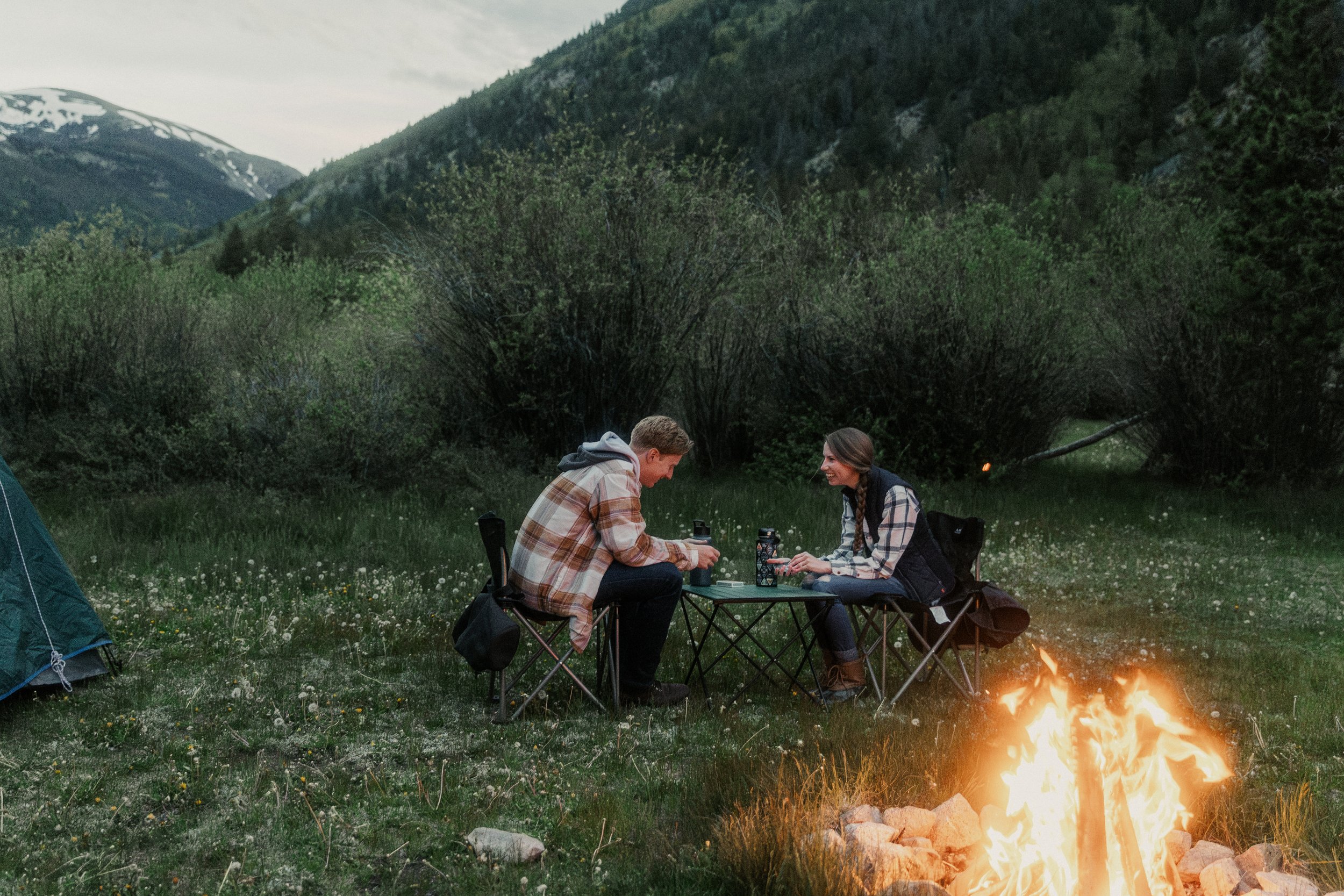 Couple playing a card game during camping engagement session in Buena Vista, Colorado.