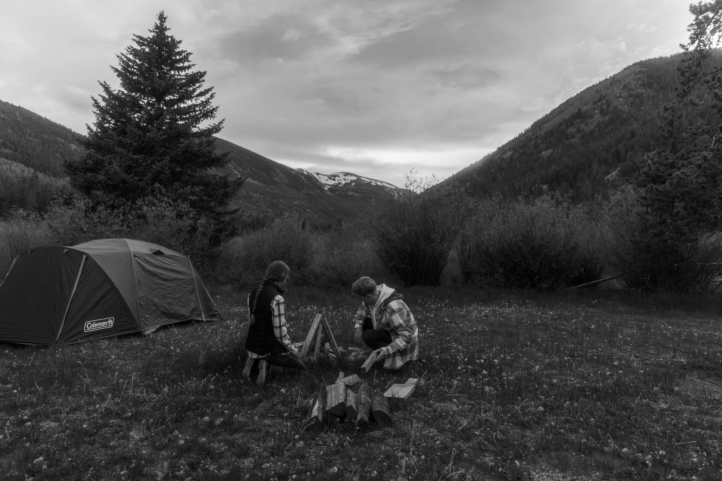 A couple making a fire at the campground for their adventure engagement session in Colorado.