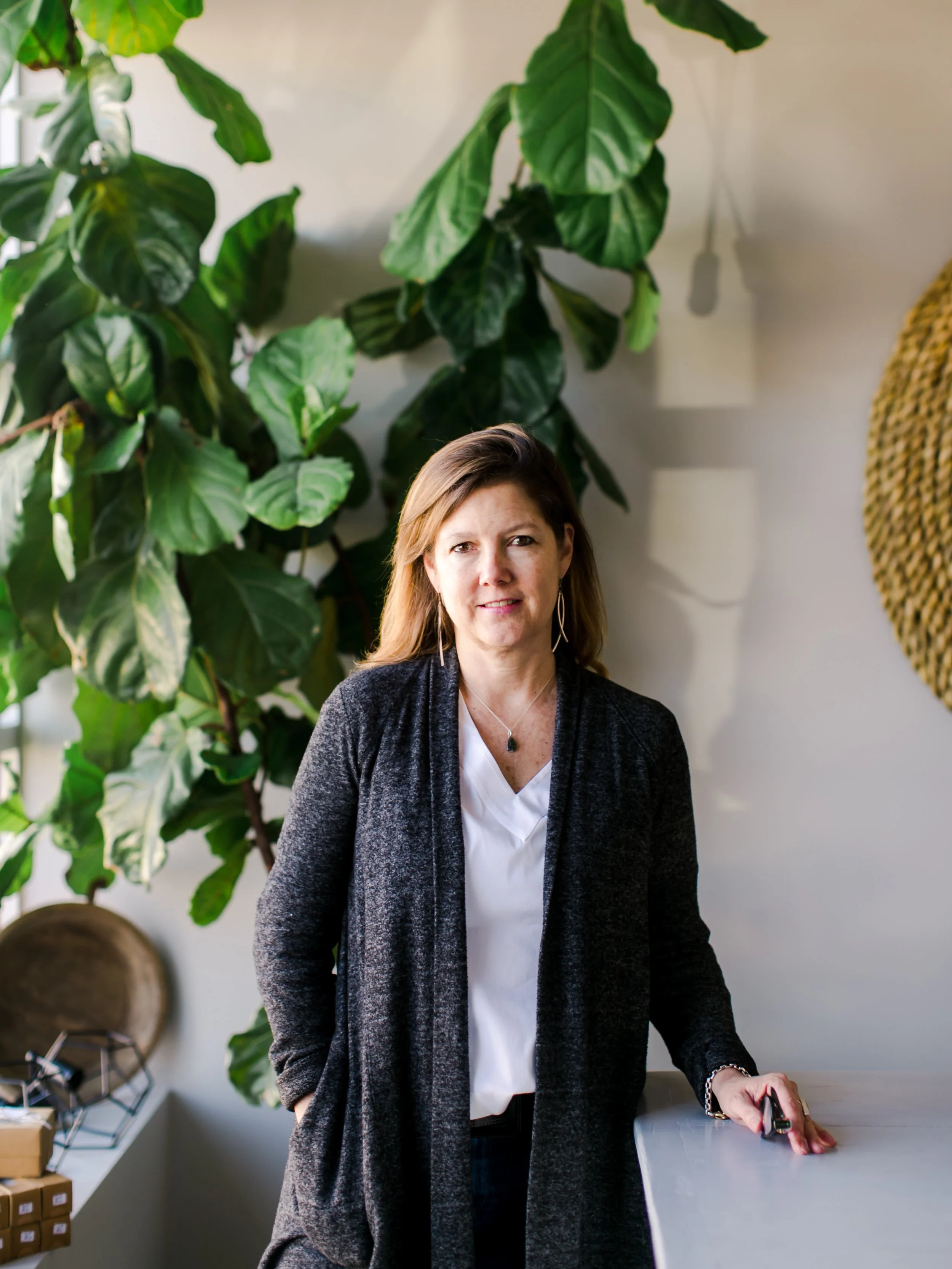 portrait of an interior designer in a sunny window with plants