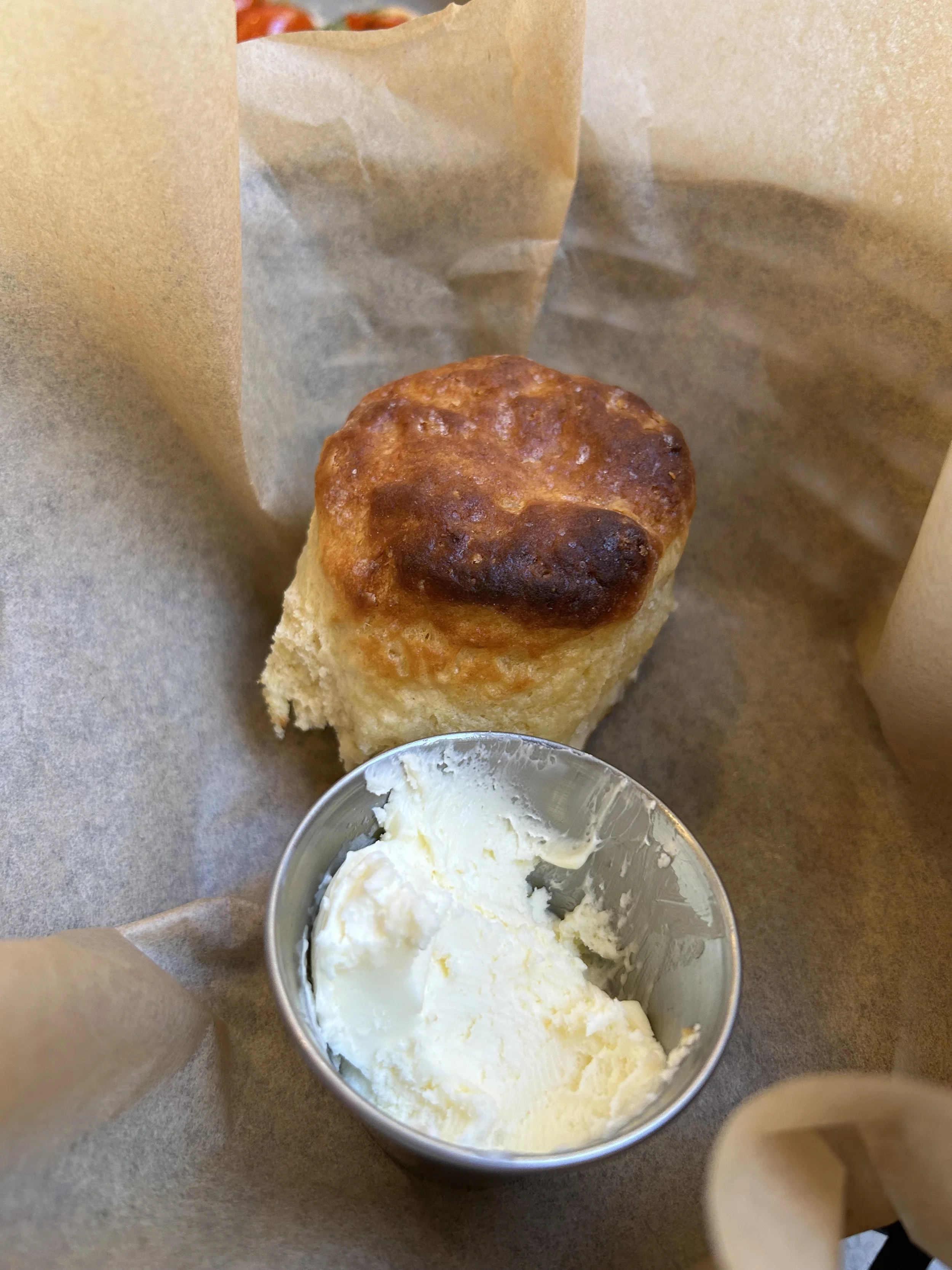 Basket of fried chicken, buttermilk biscuit, and blackened catfish over grits.