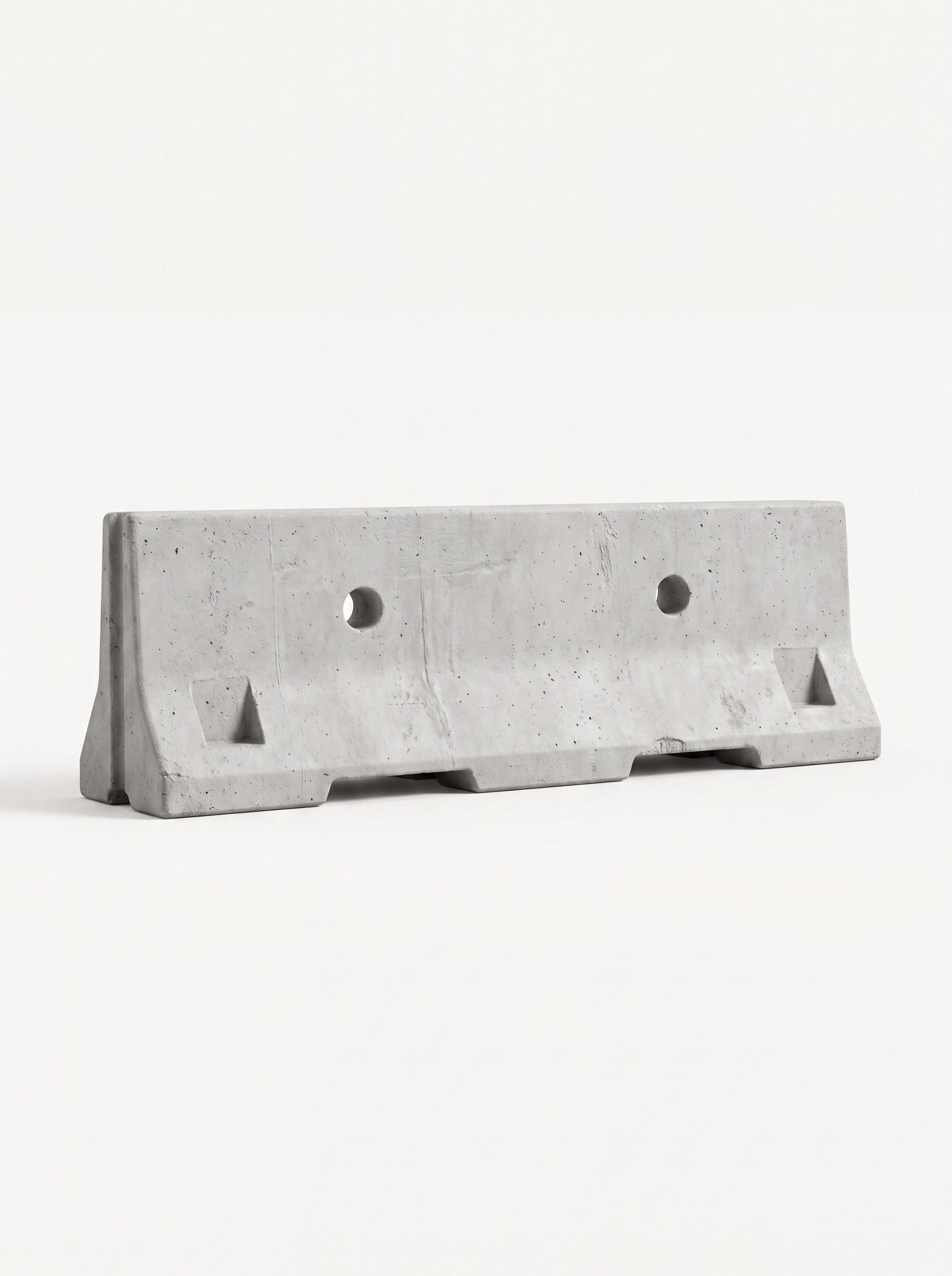 A concrete barrier with two circular holes, placed on a white surface against a plain white background.