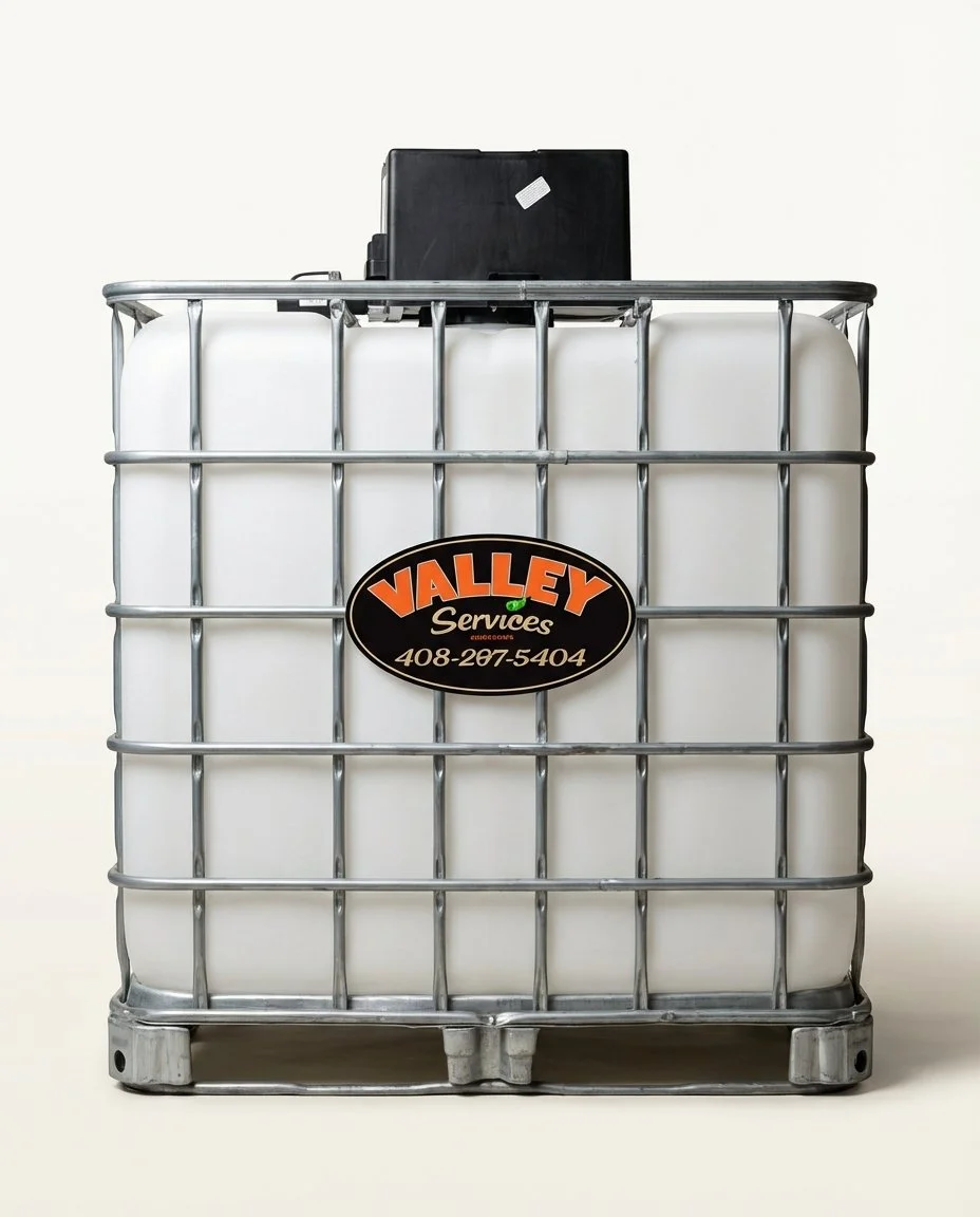 Large white plastic IBC container with metal cage, labeled "Valley Service."
