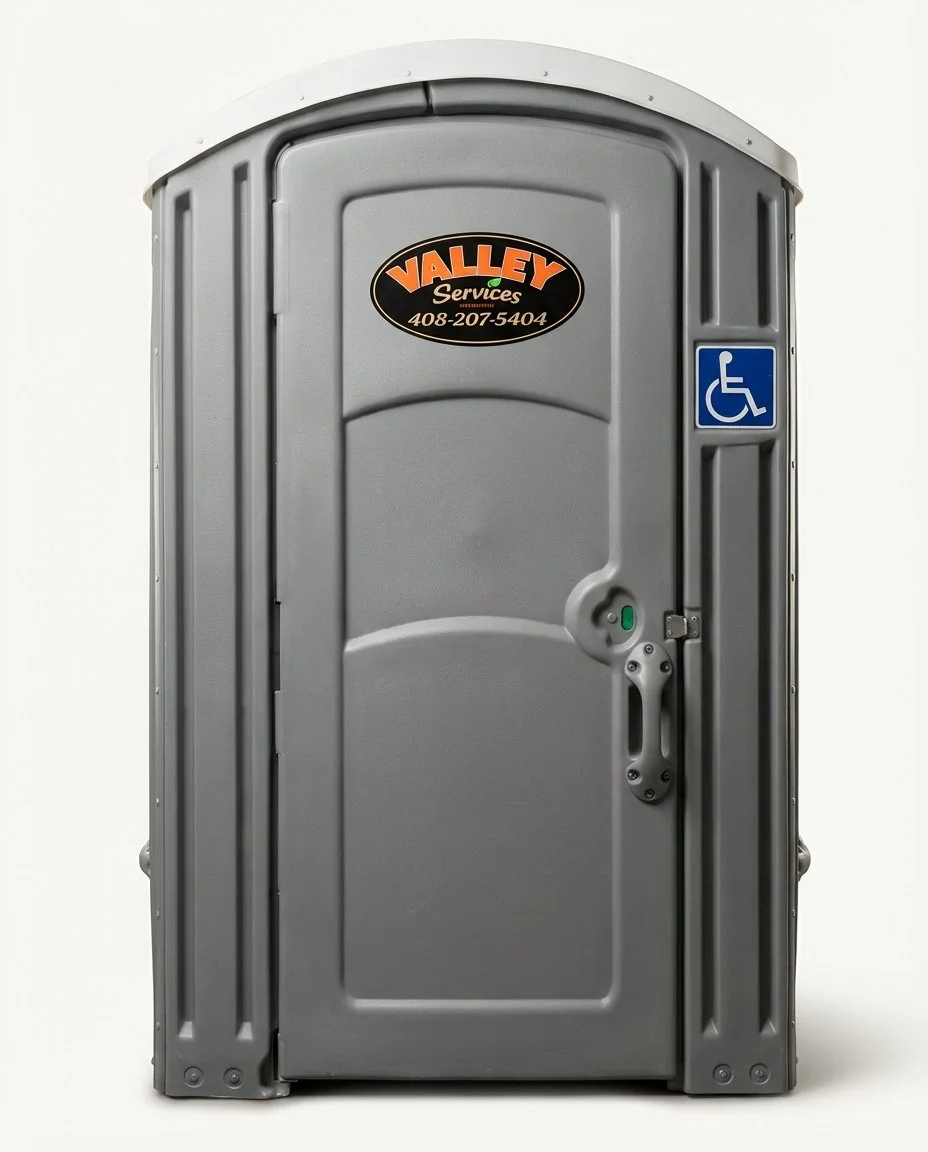 Gray portable toilet with accessibility symbol and Valley Services logo.