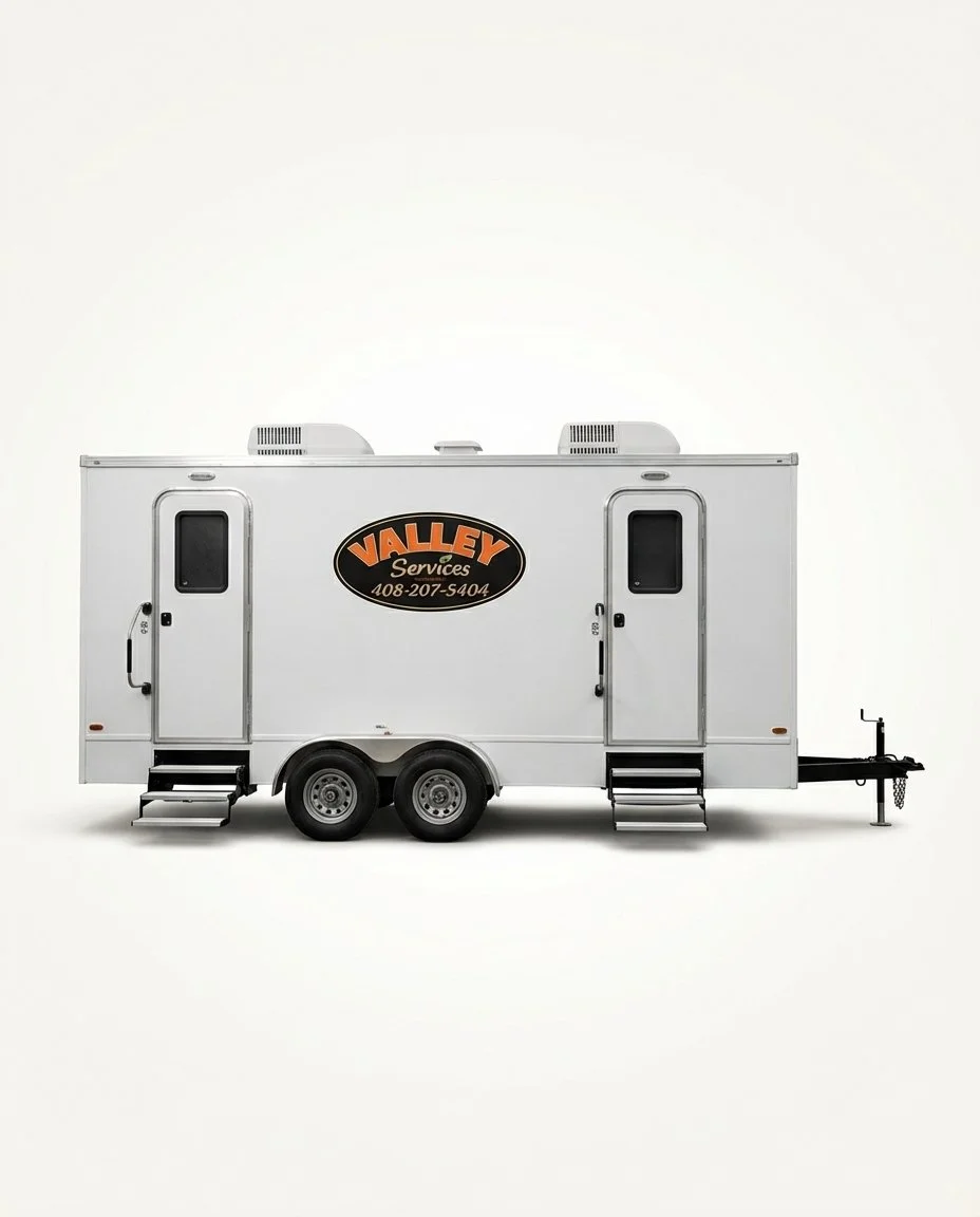 white portable restroom trailer with two steps and dual axle wheels