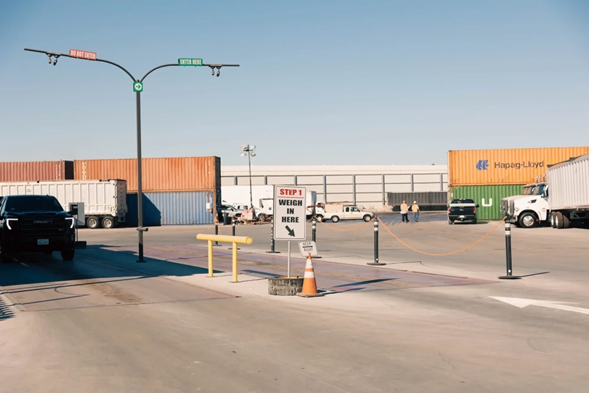 container yard with trucks and weigh-in sign