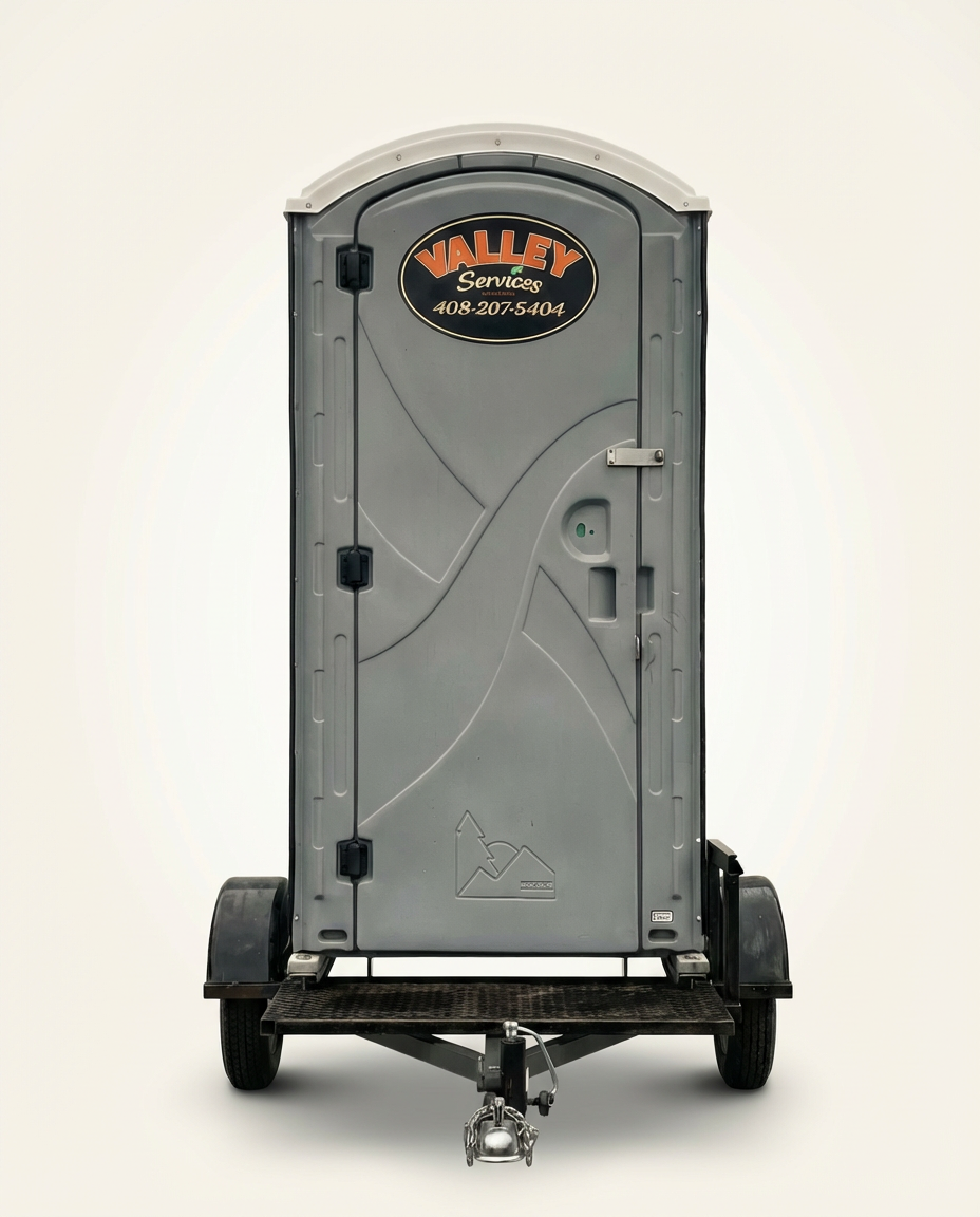 Portable toilets with Valley Services branding in an outdoor setting.
