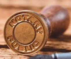 Close-up of a wooden stamp with the words 'NOTARY PUBLIC' engraved on the side.