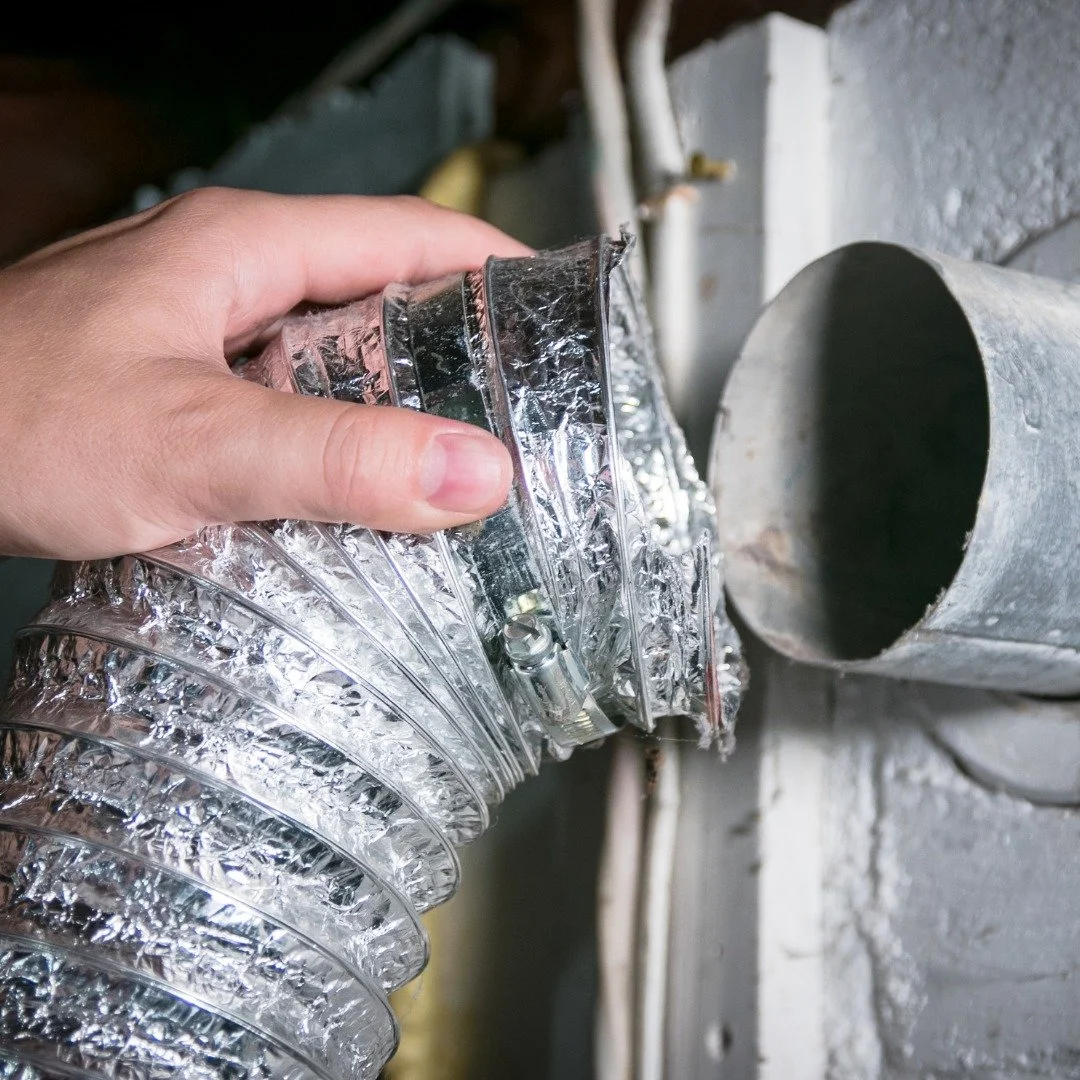 technician cleaning dryer vent and reattaching