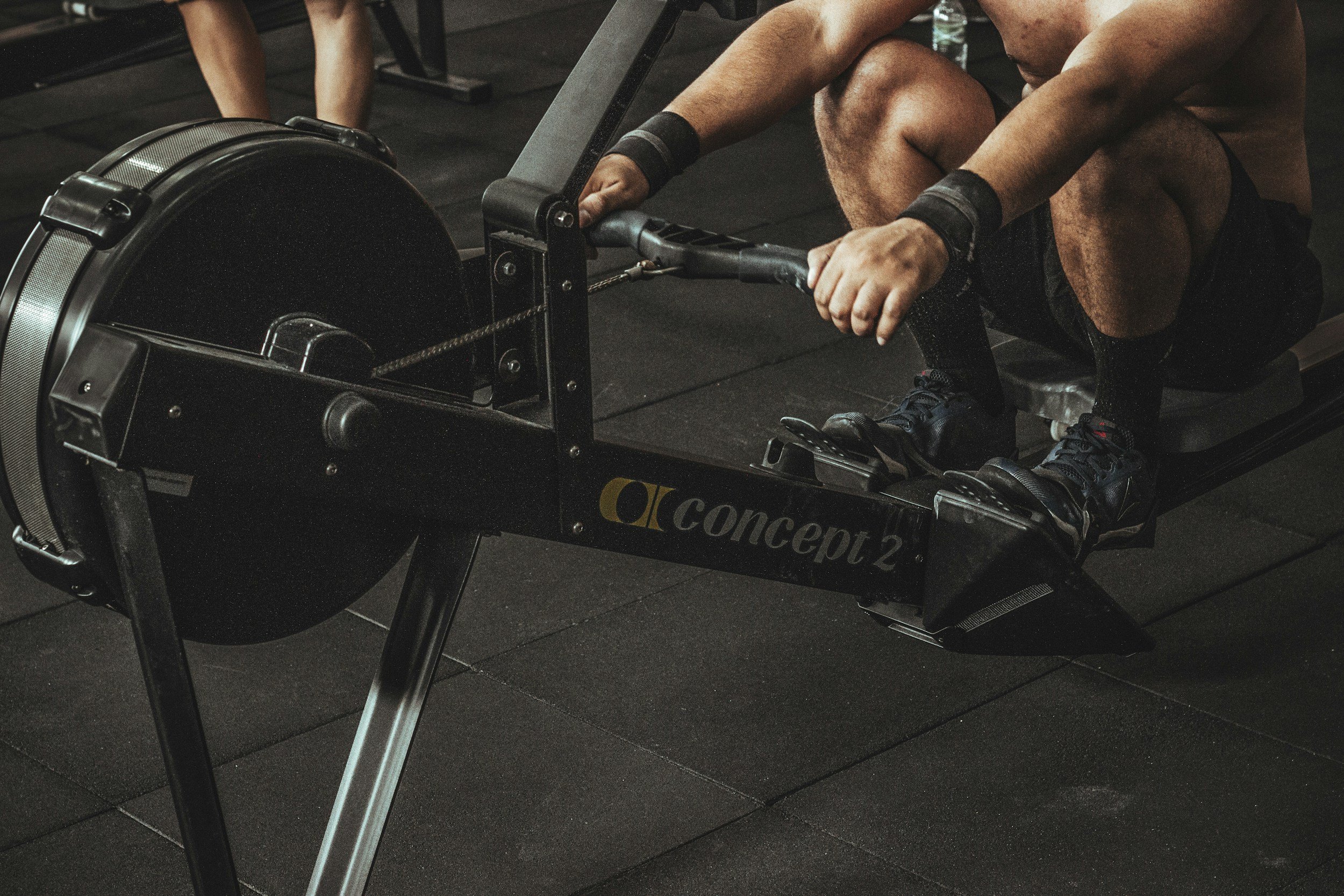 Person using a Concept 2 rowing machine in a gym.