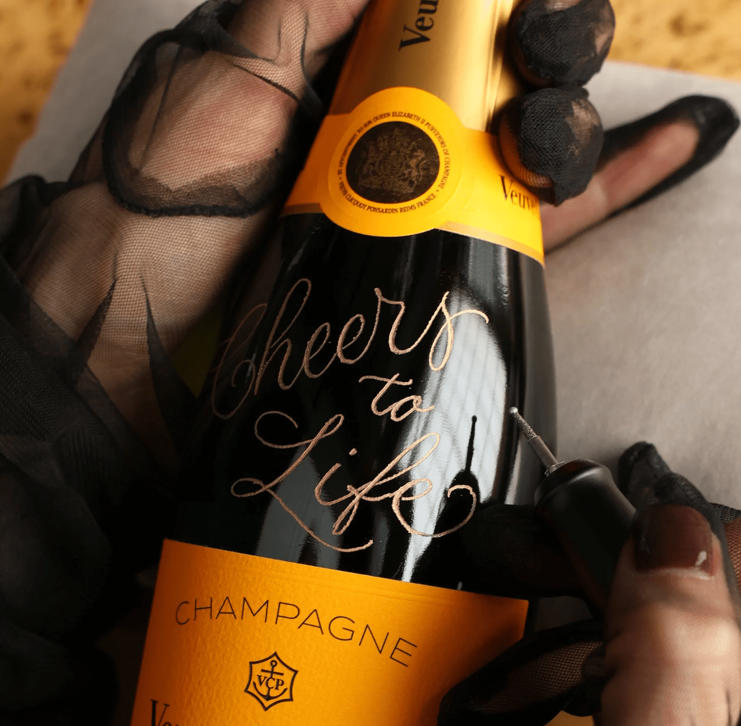 Live hand engraving on a champagne bottle for luxury event personalization in Toronto
